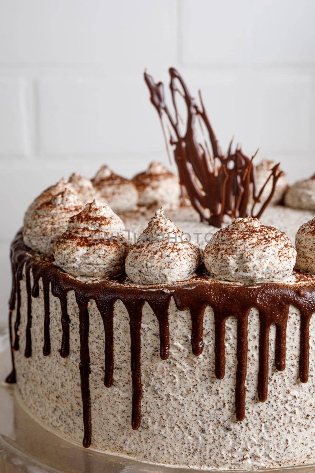 Round creamy cake with chocolate and cinnamon on the wooden table