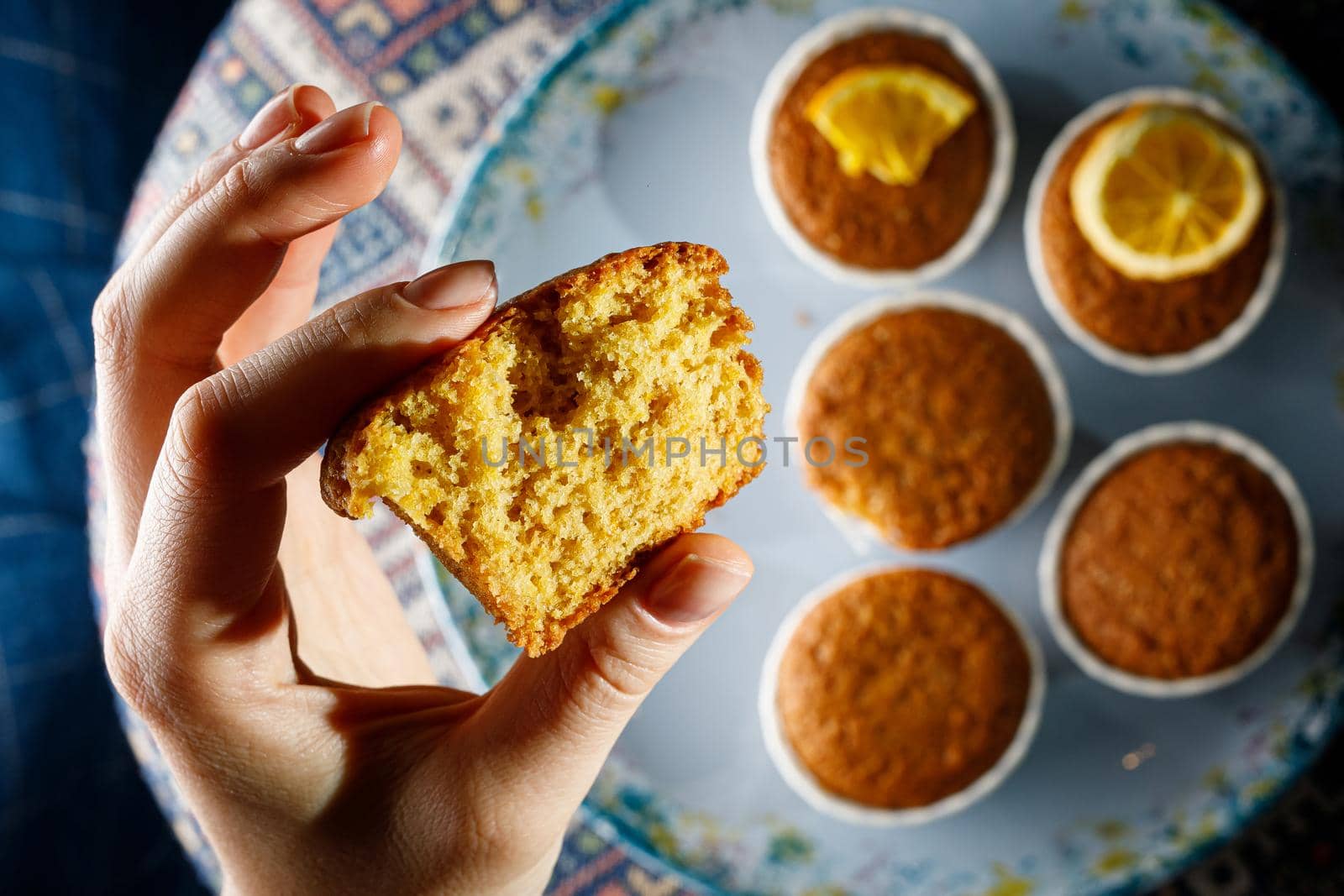 Girl holding fresh cupcake in her hand. Close-up texture of the dough