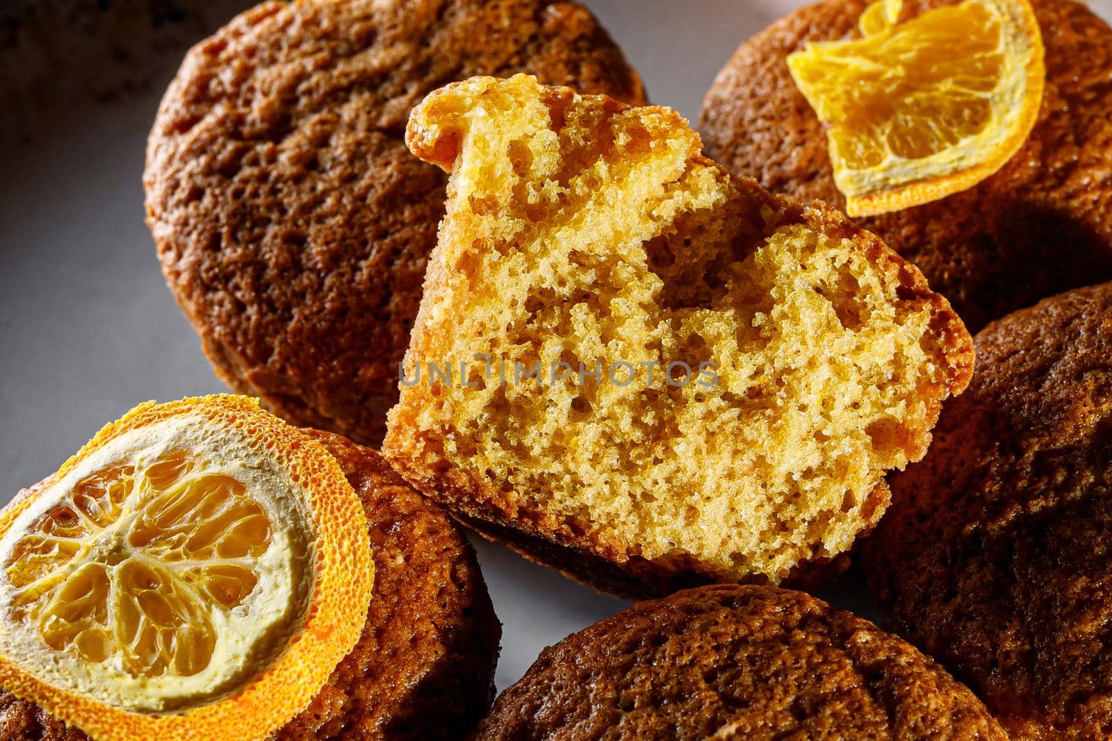 Fresh orange muffins on a round plate.