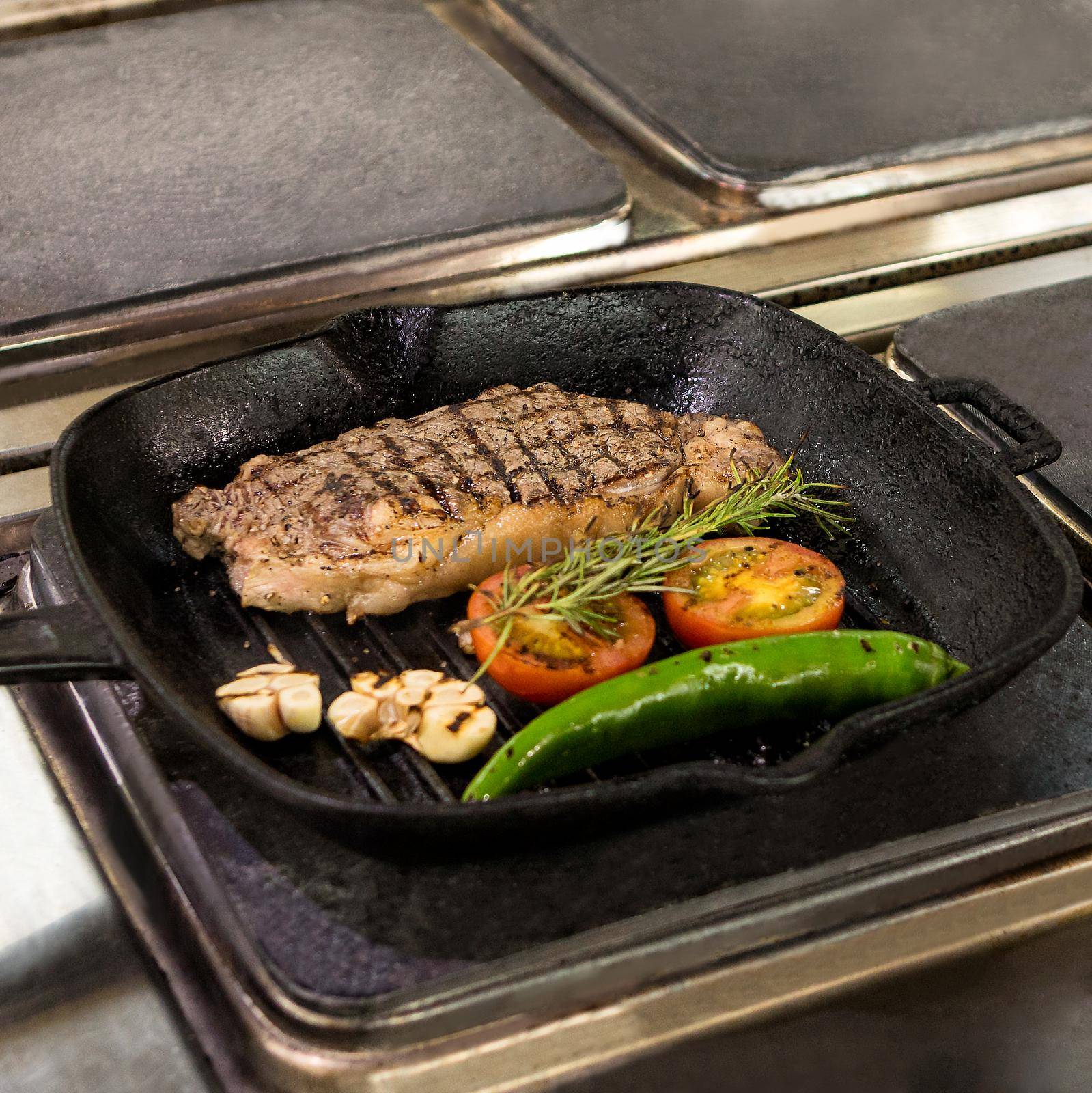 Tasty steak with vegetable cooking in the pan at kitchen by ferhad