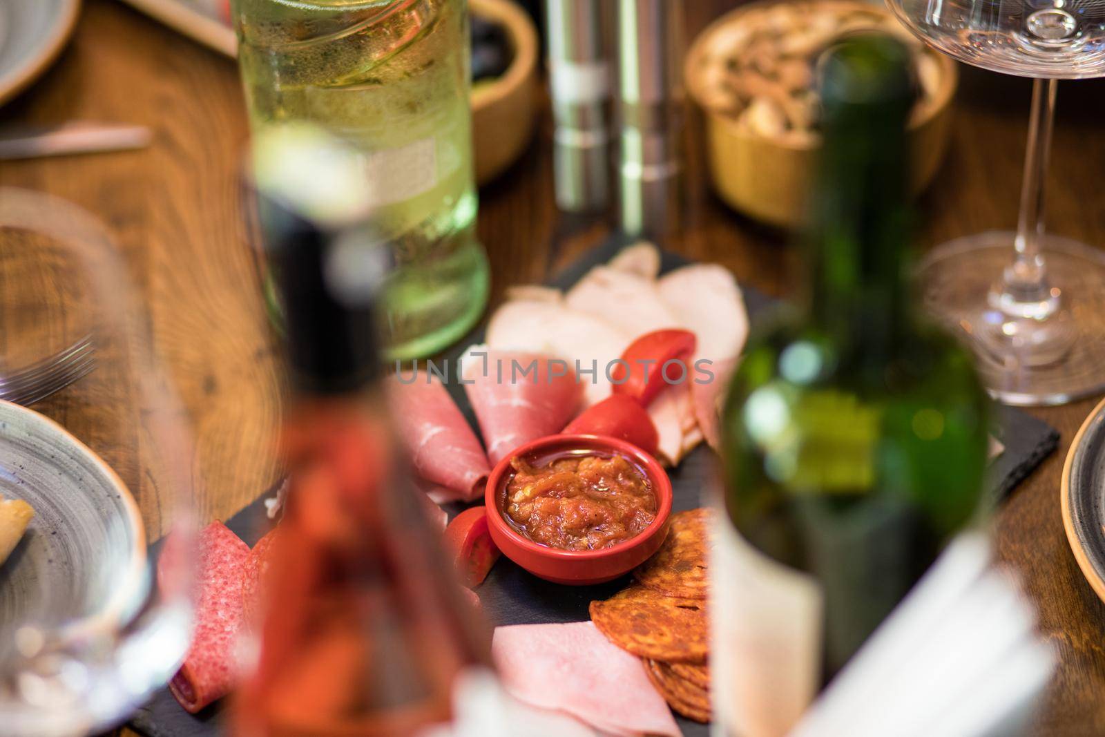 Tasty sausage with tomato and sauce with wine bottles by ferhad