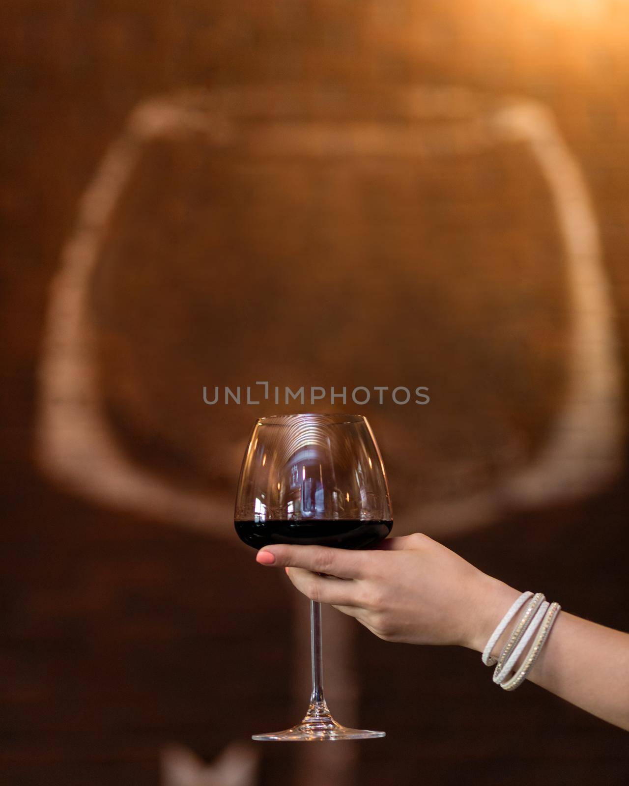 Woman holding red wine glass with glass shape background