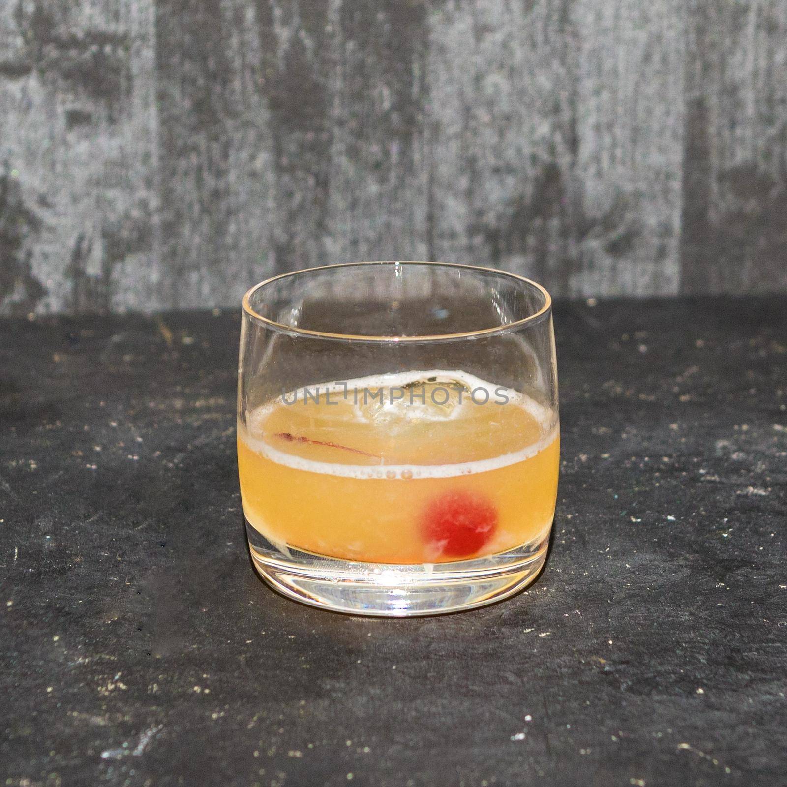 Alcoholic cocktail drink in the glass, gray background