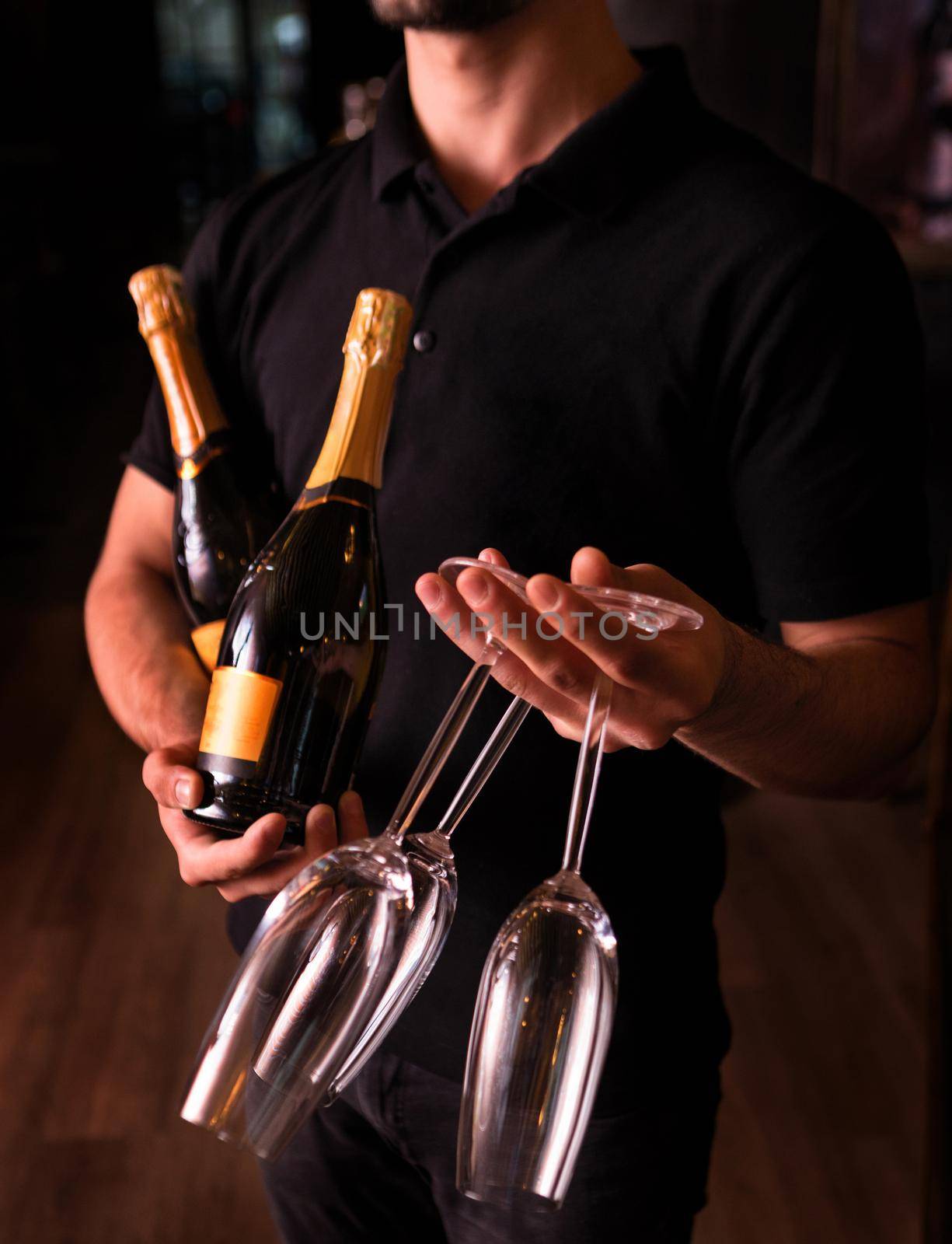 Man holding Champagne and glasses on dark background by ferhad