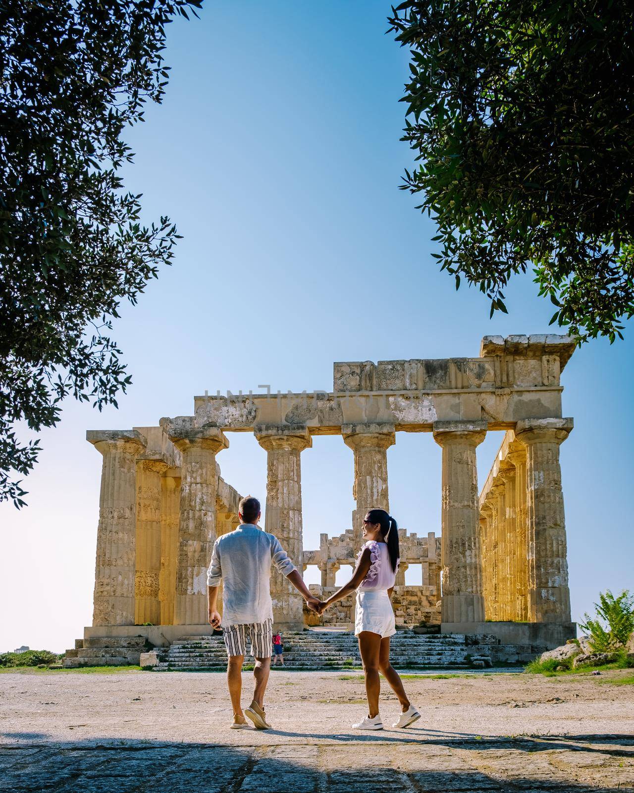 A couple visit Greek temples at Selinunte during vacation, View on sea and ruins of greek columns in Selinunte Archaeological Park Sicily Italy