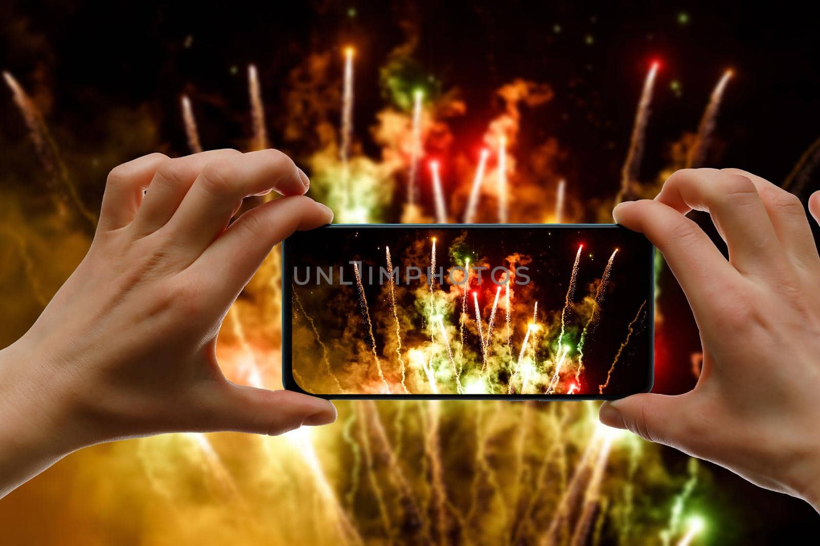 Taking the photo of fireworks via smartphone. Broadcast salute video to the internet. by 9parusnikov