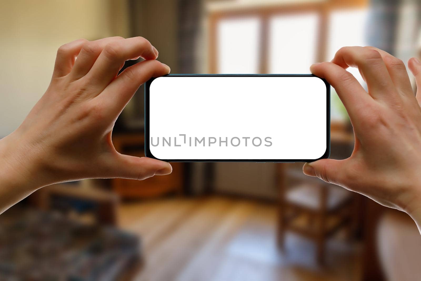 Mockup of using a smartphone in the home interior. Blank white screen for your idea. by 9parusnikov