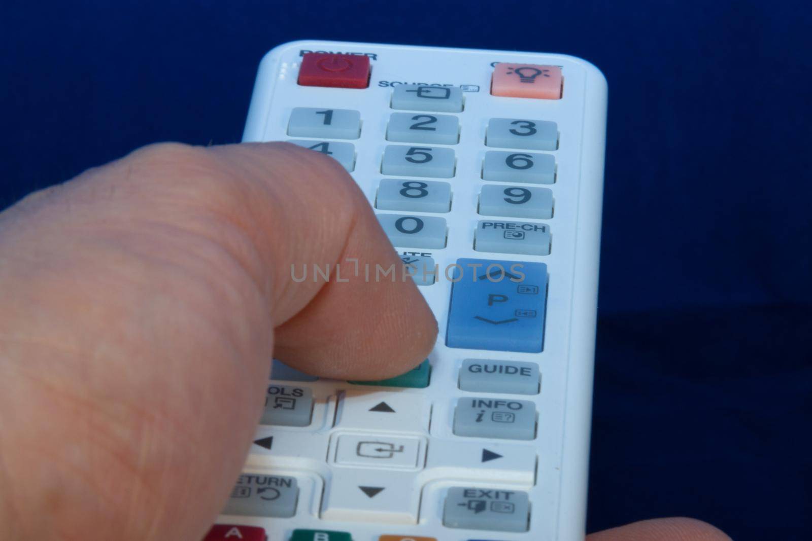 finger presses the button on the remote control, white by client111