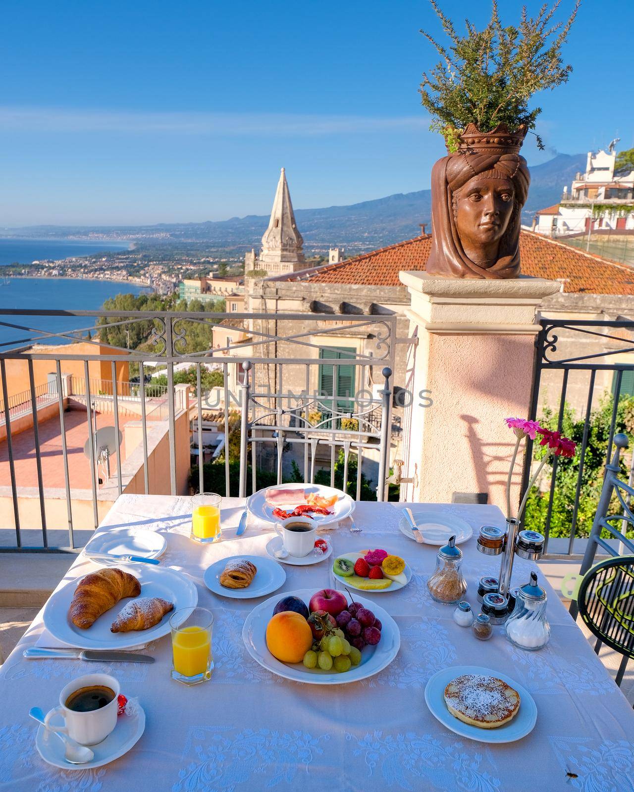 Taormina Sicily Italy breakfast table with a rooftop view over Taormina breakfast with coffee bread and fruit