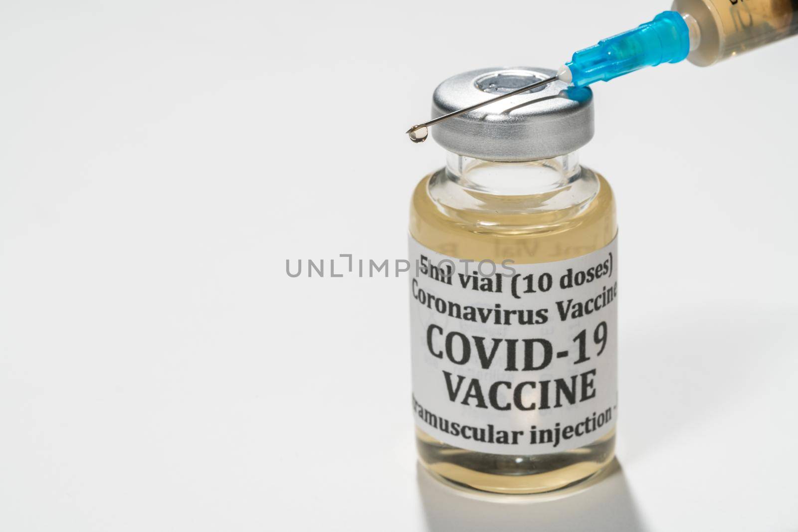 Covid-19 coronavirus vaccine with hypodermic syringe needle with droplet of liquid on tip