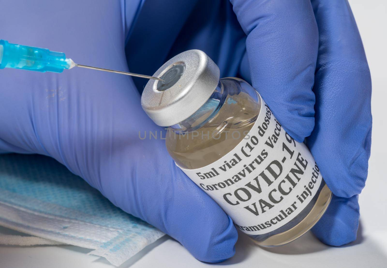 Covid-19 coronavirus vaccine with hypodermic syringe needle being inserted into the vaccination bottle