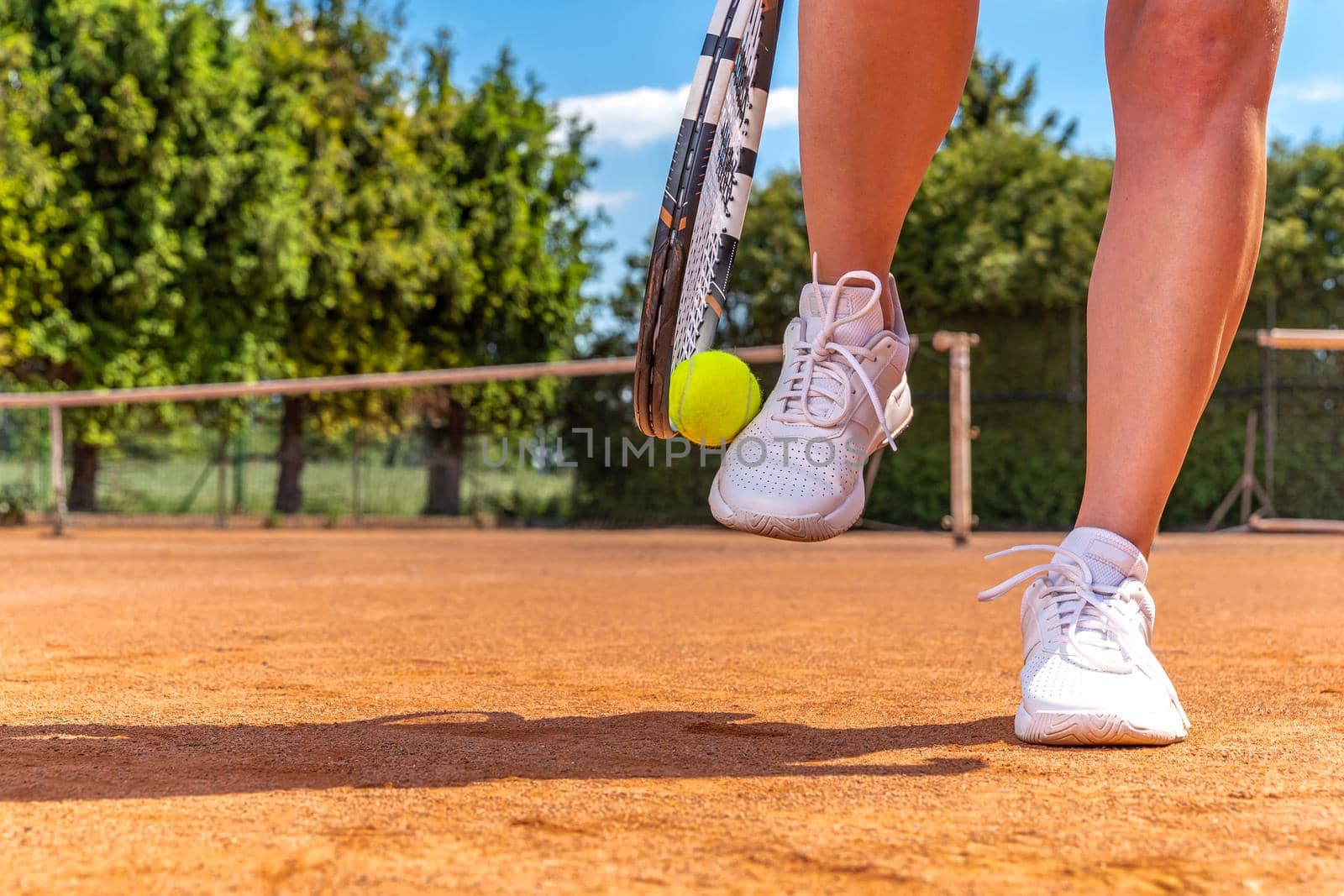 close-up on tennis player on court, racket, ball and shoes.