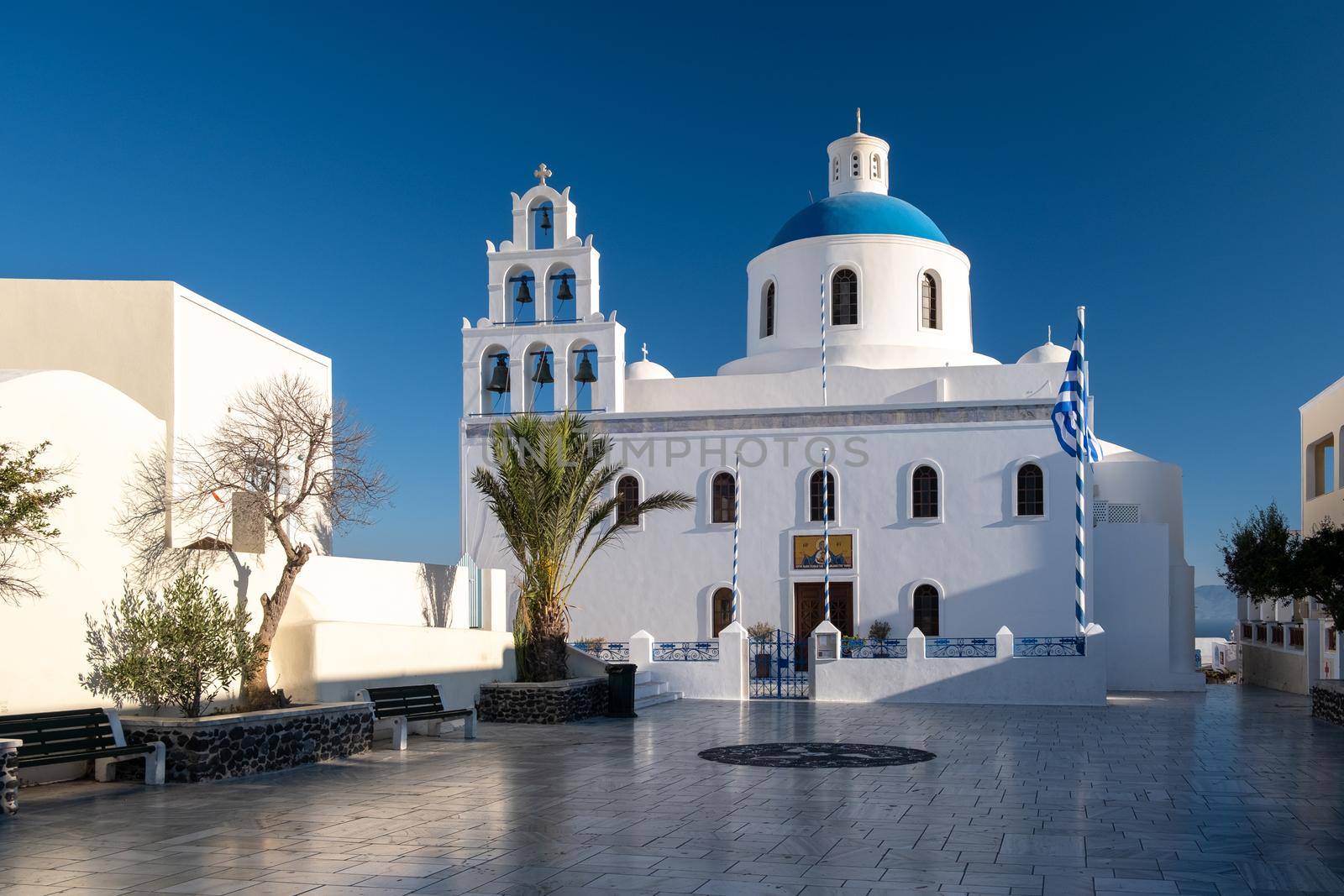 Sunset at the Island Of Santorini Greece, beautiful whitewashed village Oia with church and windmill during sunset, streets of Oia Santorini during summer vacation at the Greek Island