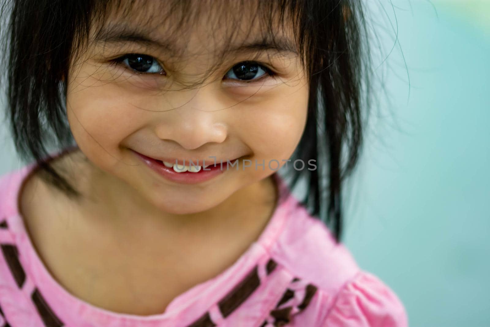 Pretty little girl close up shot while smiling and shoeing her cute teeth
