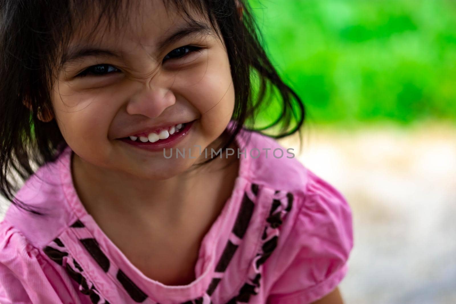 Pretty little girl close up shot while smiling and shoeing her cute teeth