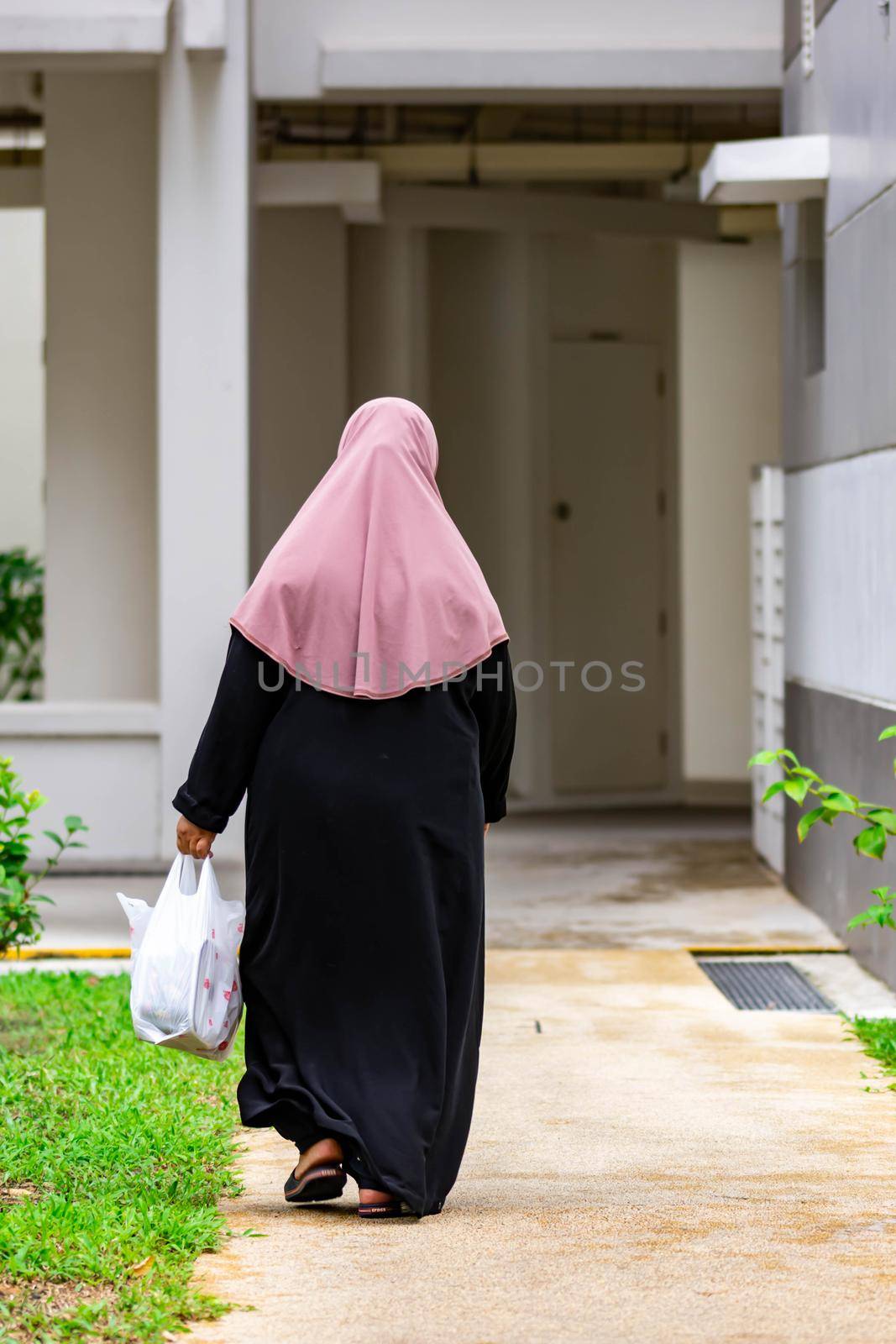 Old female muslim back shot while walking on a street