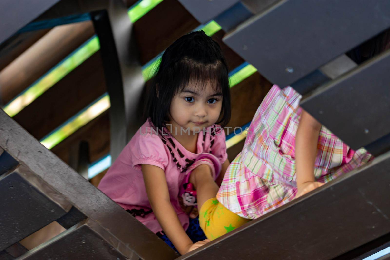 Pretty asian identical twins while enjoying and playing on a playground