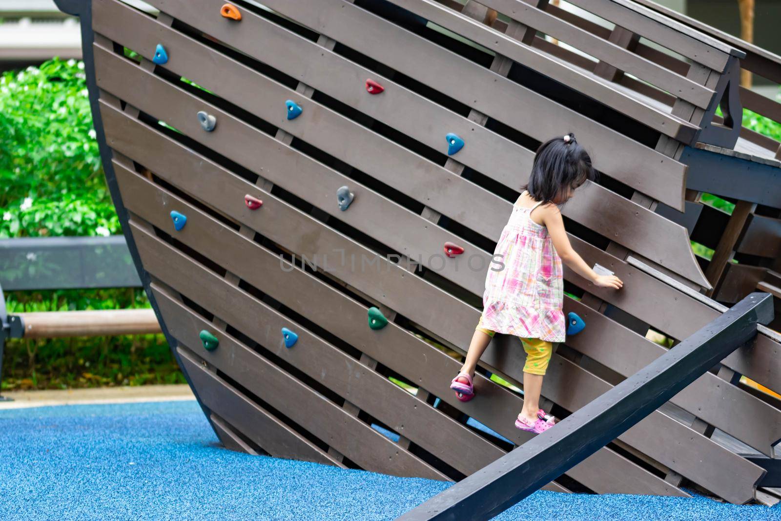 Pretty asian little girls while climbing in a playground