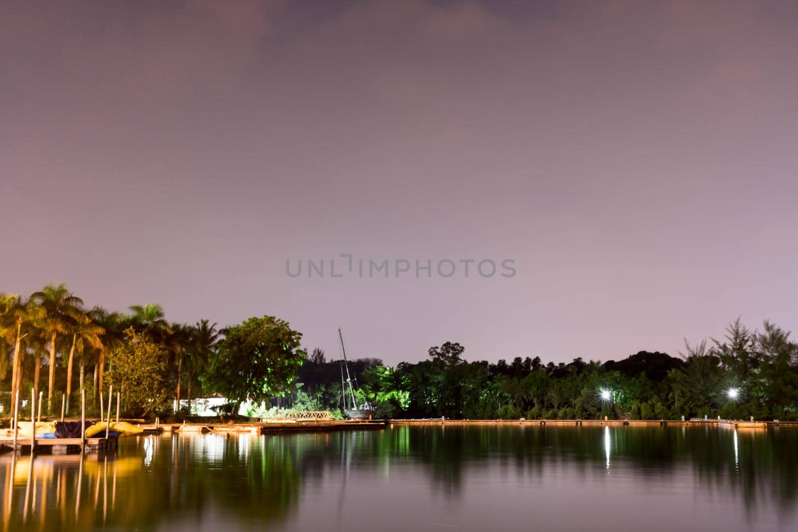 Horizontal view of lake and nature during dusk with night stars and smooth reflection on waters somewhere in Asia