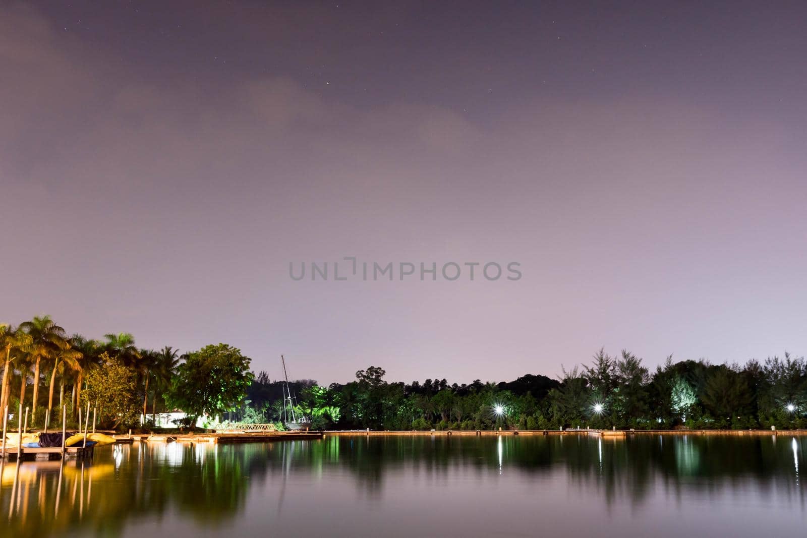 Horizontal view of lake and nature during dusk with night stars and smooth reflection on waters somewhere in Asia