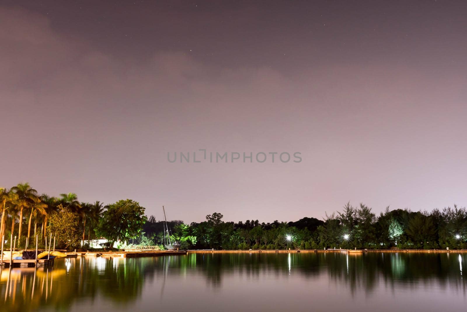 Horizontal view of lake and nature during dusk with night stars and smooth reflection on waters somewhere in Asia