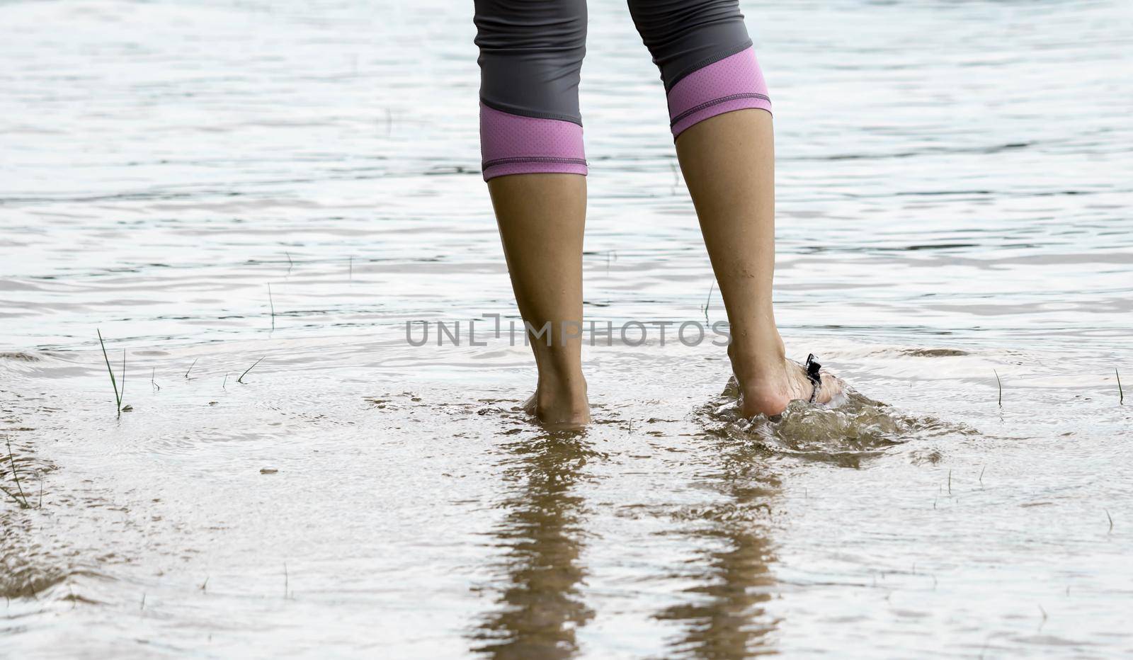 Female feet while walking in a beach waters