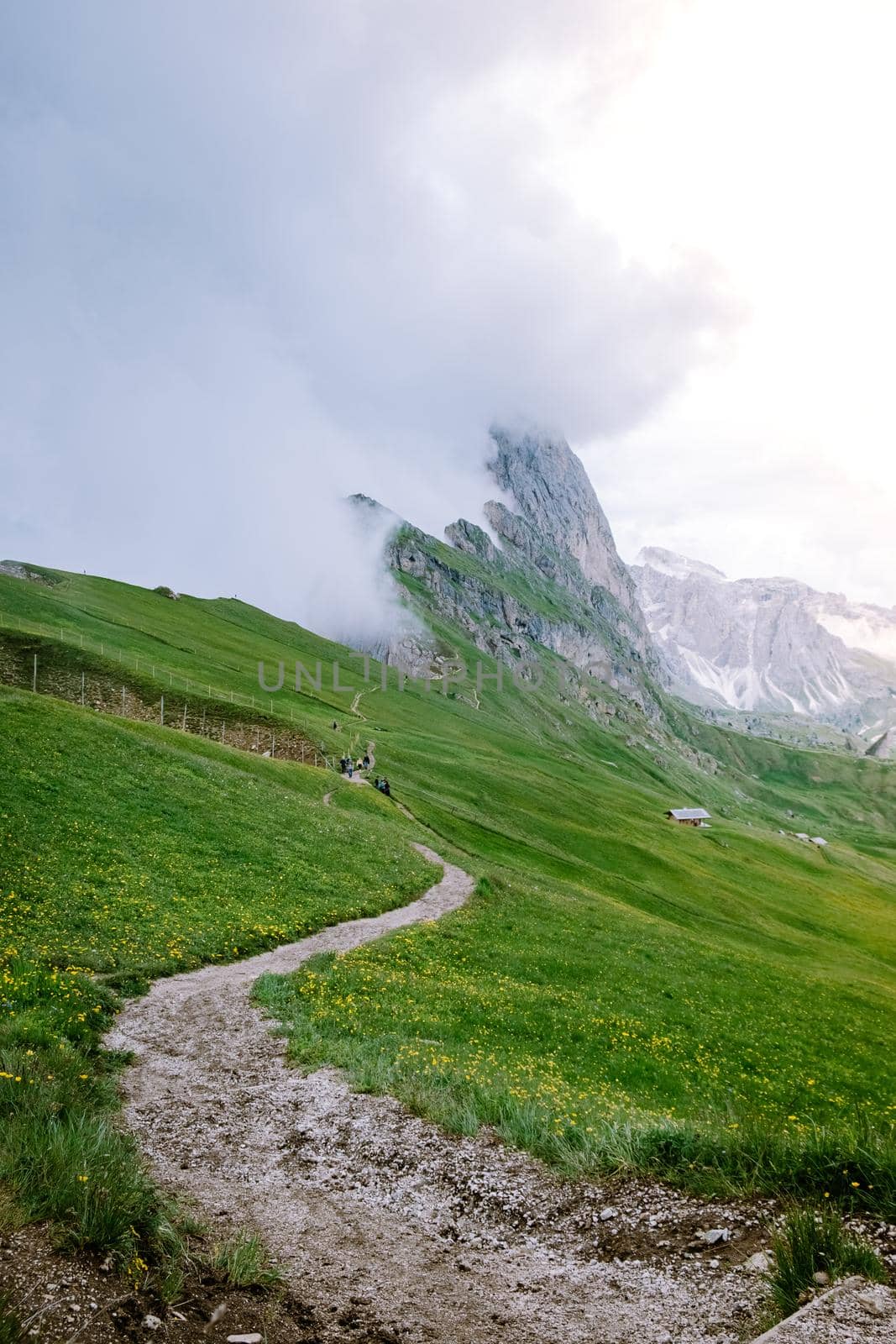 couple on vacation hiking in the Italien Dolomites, Amazing view on Seceda peak. Trentino Alto Adige, Dolomites Alps, South Tyrol, Italy, Europe. Odle mountain range, Val Gardena. Majestic Furchetta peak in morning sunlight by fokkebok