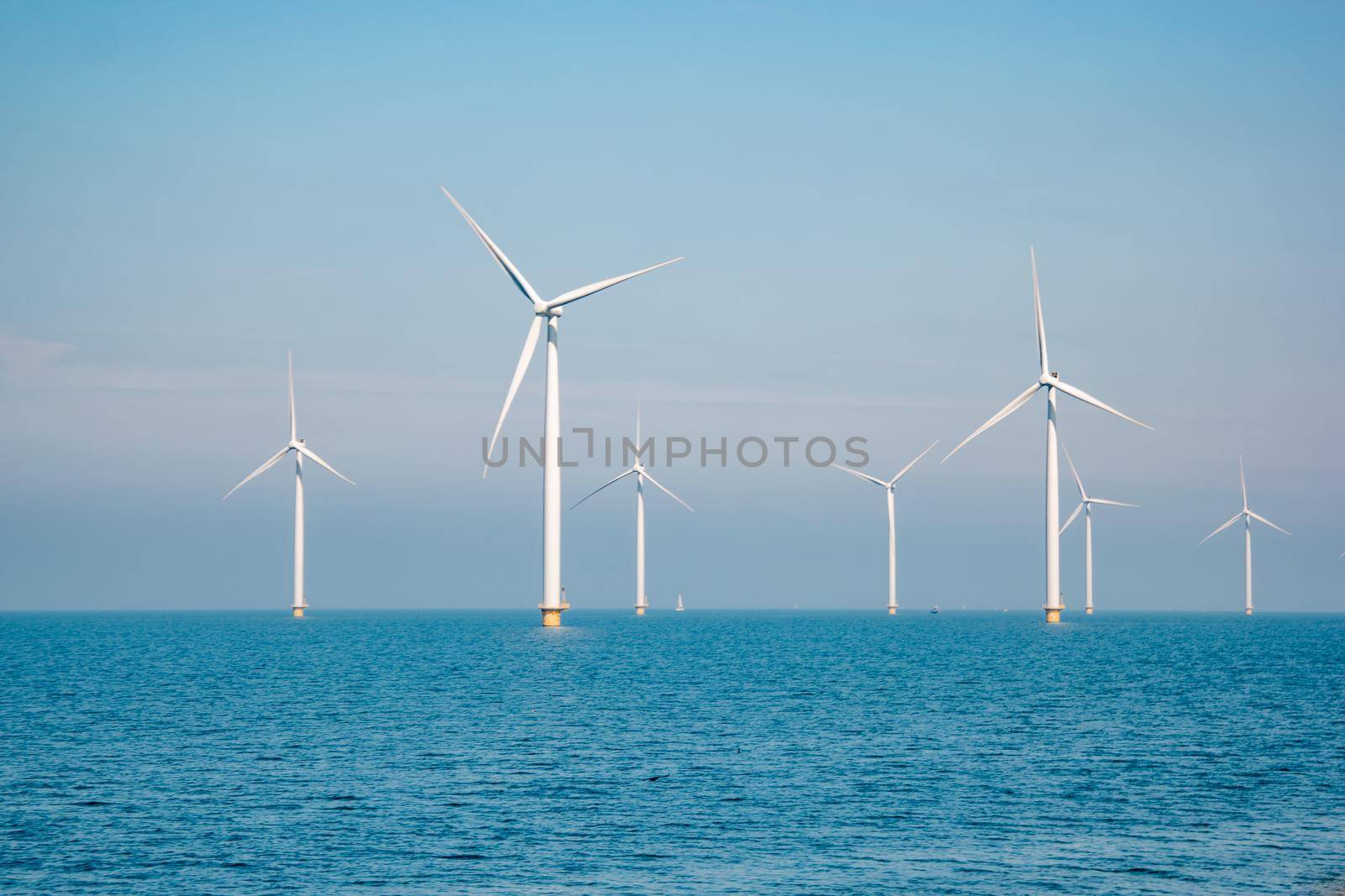 offshore windmill park with stormy clouds and a blue sky, windmill park in the ocean by fokkebok