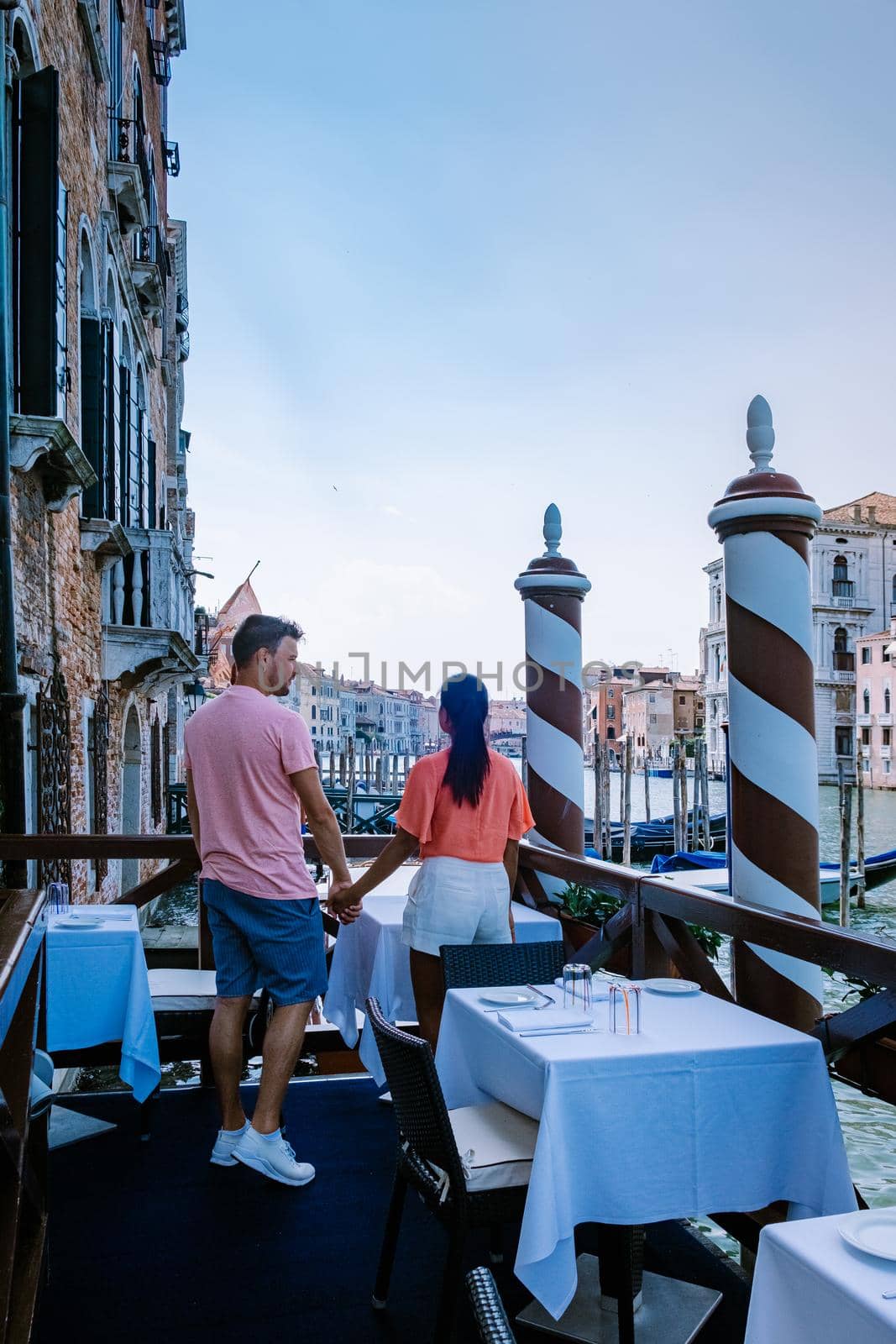 couple men and woman on a city trip to Venice Italy, colorful streets with canals Venice by fokkebok