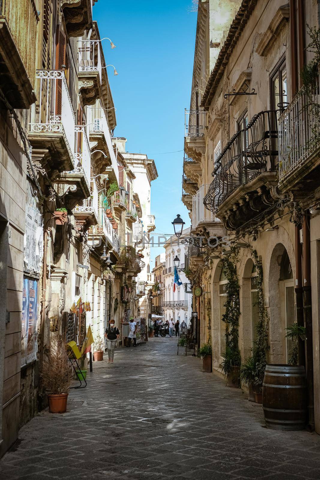 Ortigia in Syracuse in the Morning. Travel Photography from Syracuse, Italy on the island of Sicily. Cathedral Plaza and market with people whear face protection during the 2020 pandemic by fokkebok