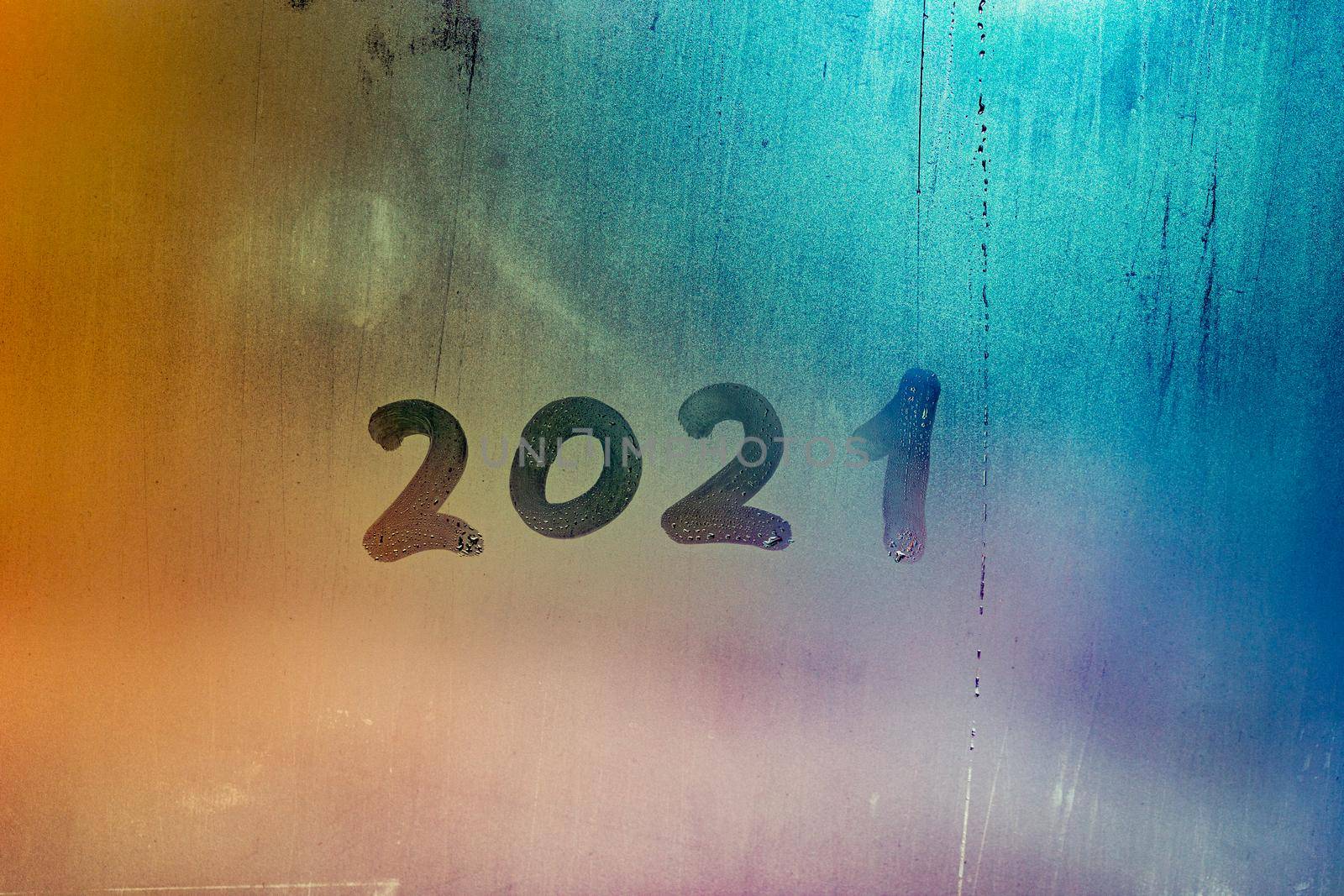 digit 2021 handwritten on wet night window glass surface, close-up with selective focus