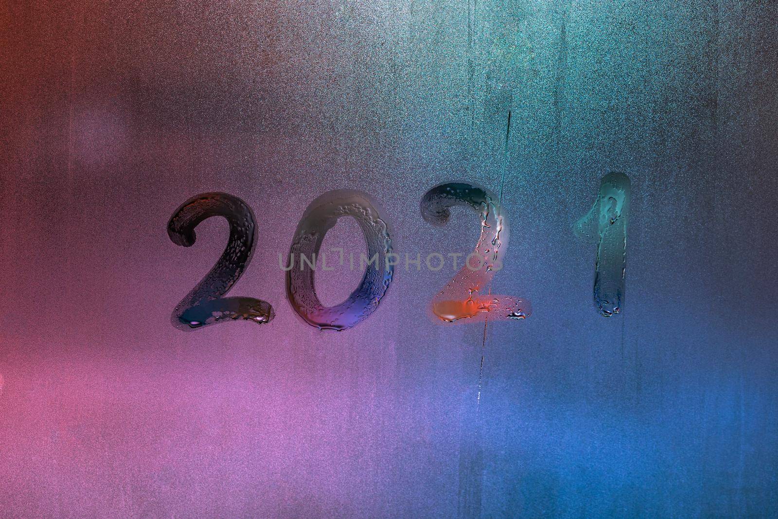 digit 2021 handwritten on wet night window glass surface, close-up with selective focus