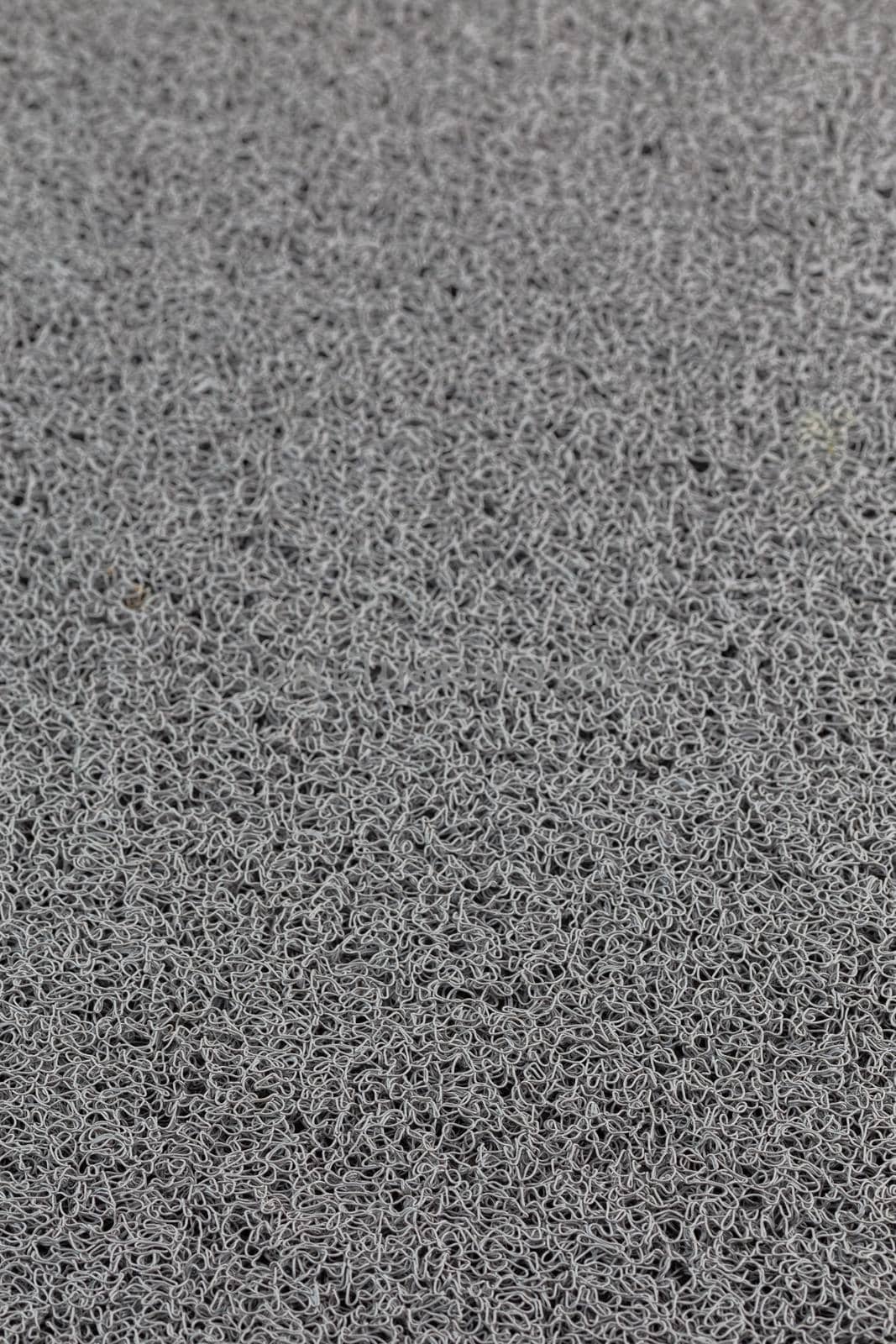 abstract gray background of rubber hair synthetic welcome mat with selective focus and blur.