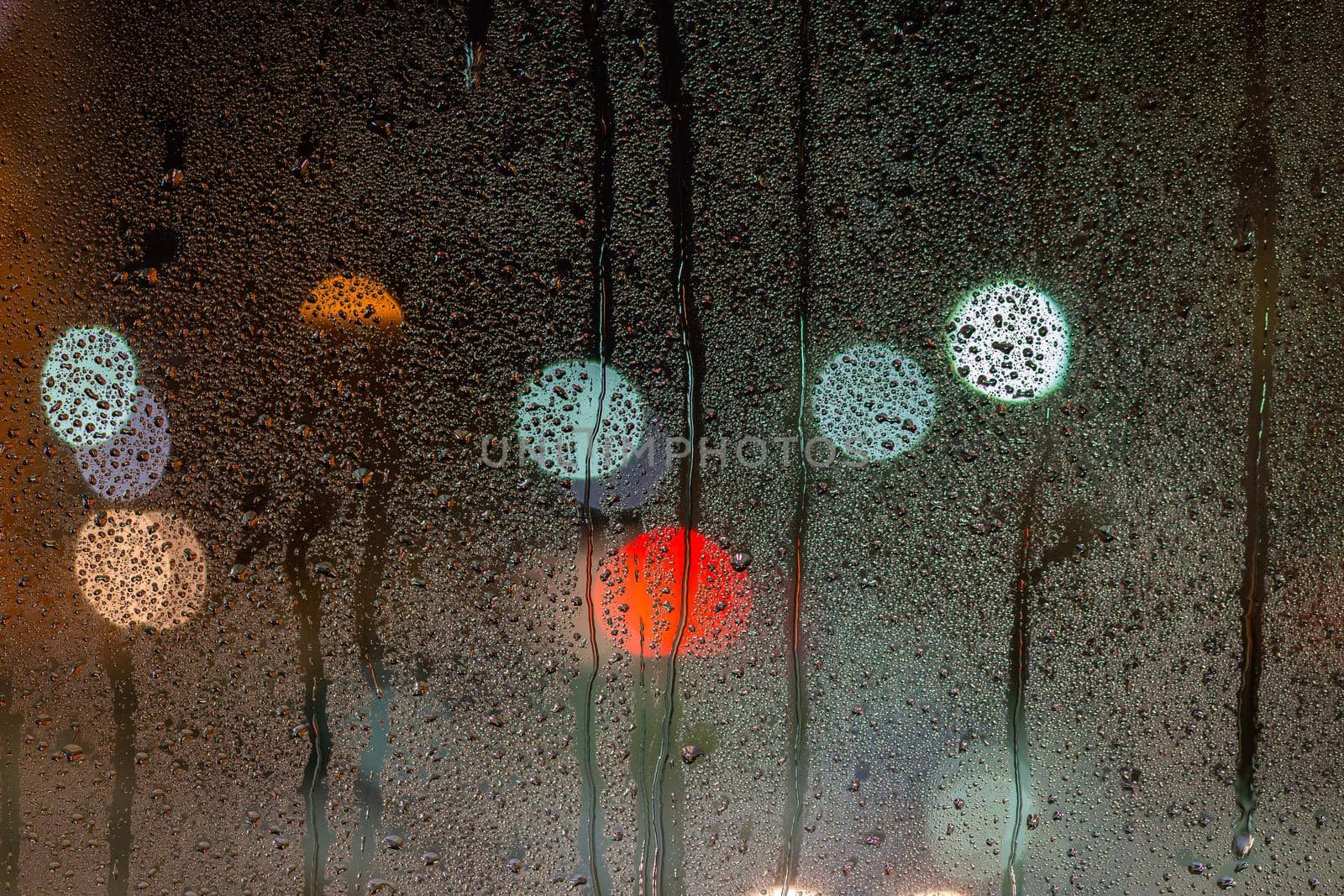 an abstract background of night wet window glass with smudges.