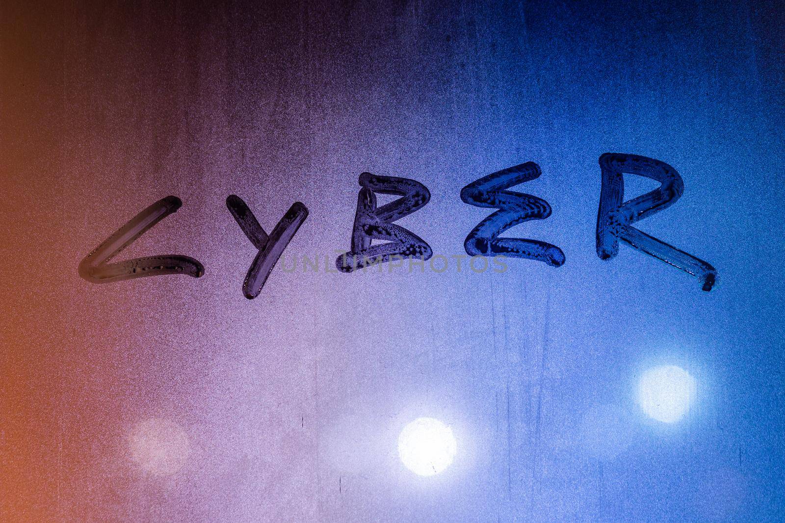 the word cyber handwritten on night wet glass surface, close-up conceptual background