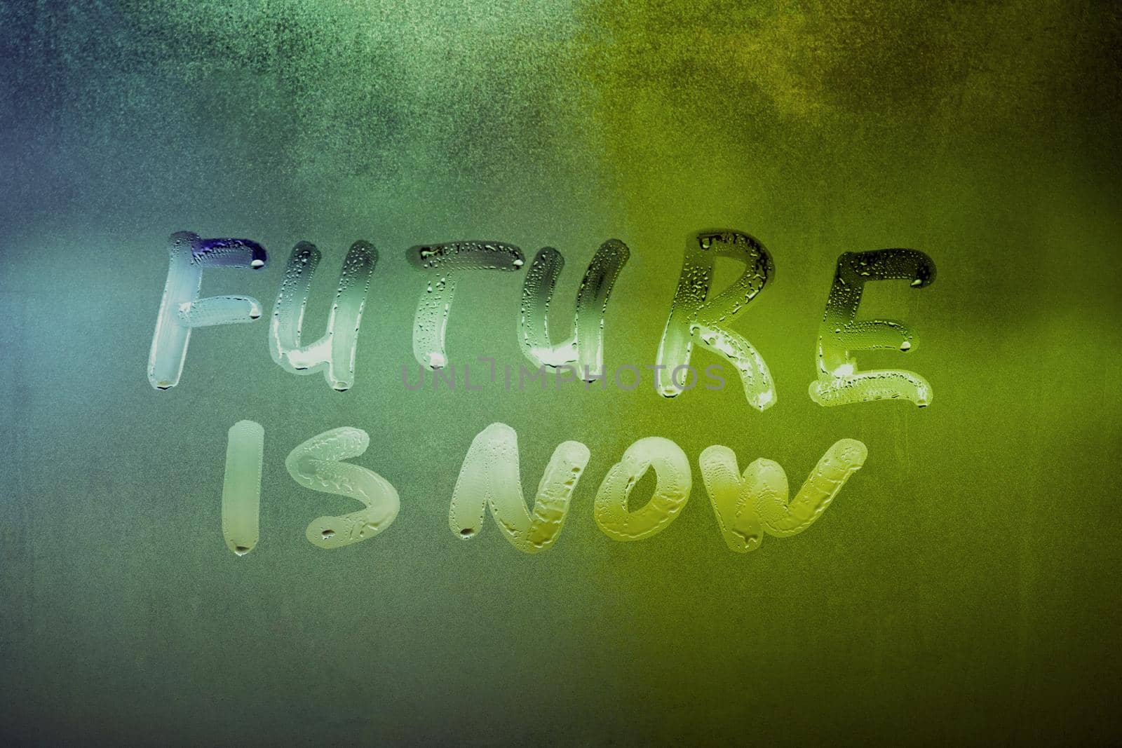 words future is now handwritten on night foggy window glass surface, close-up with selective focus