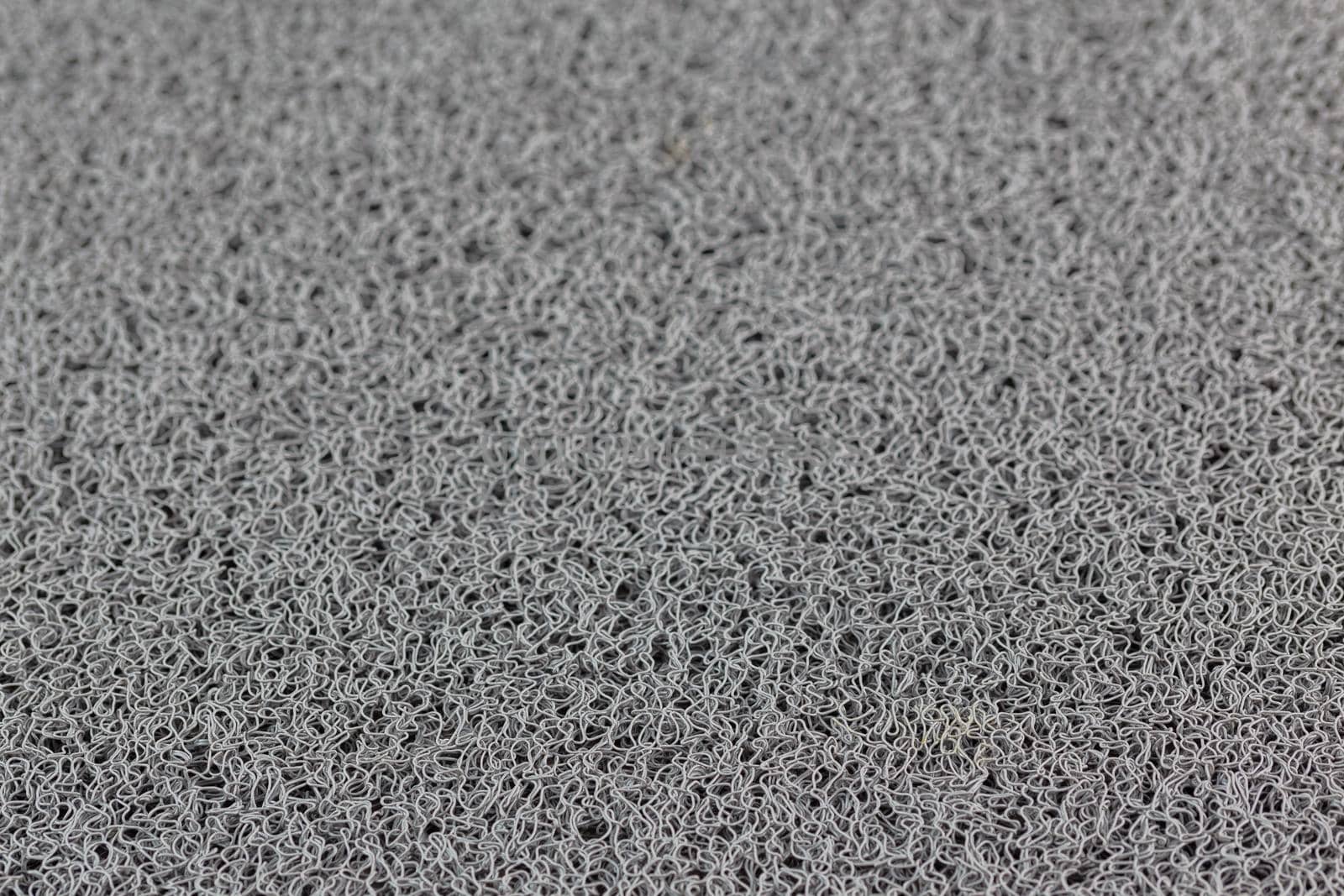 abstract gray background of rubber hair synthetic welcome mat with selective focus and blur.
