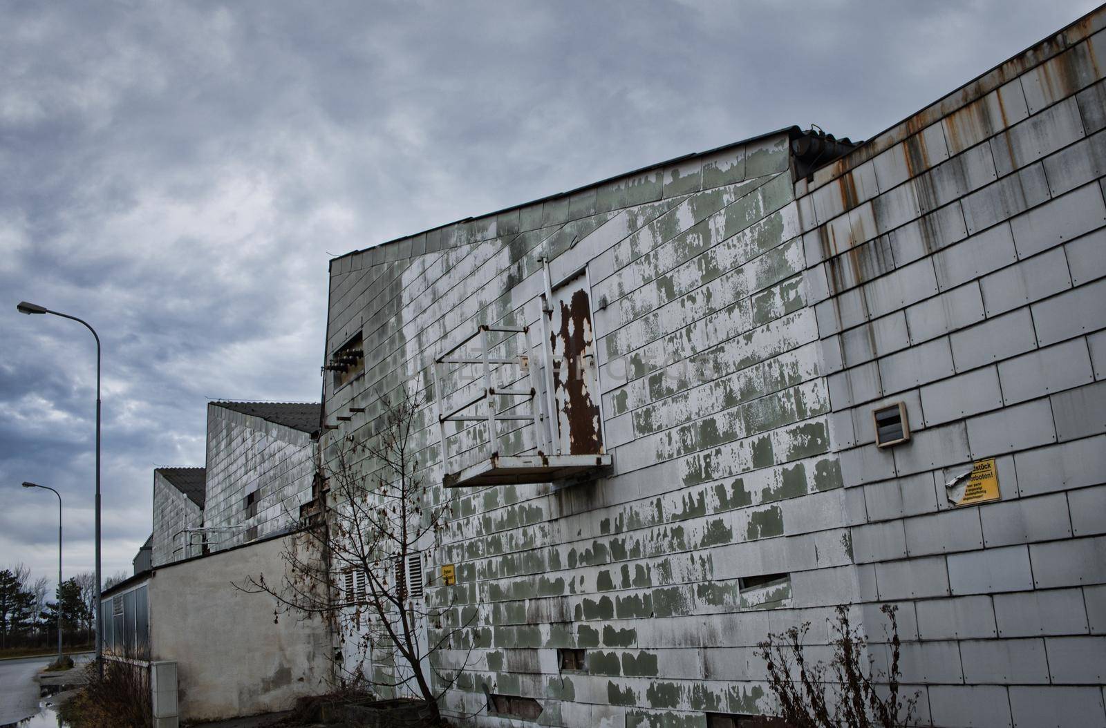 Old industrial area, cold winter day, cloudy sky, green old building