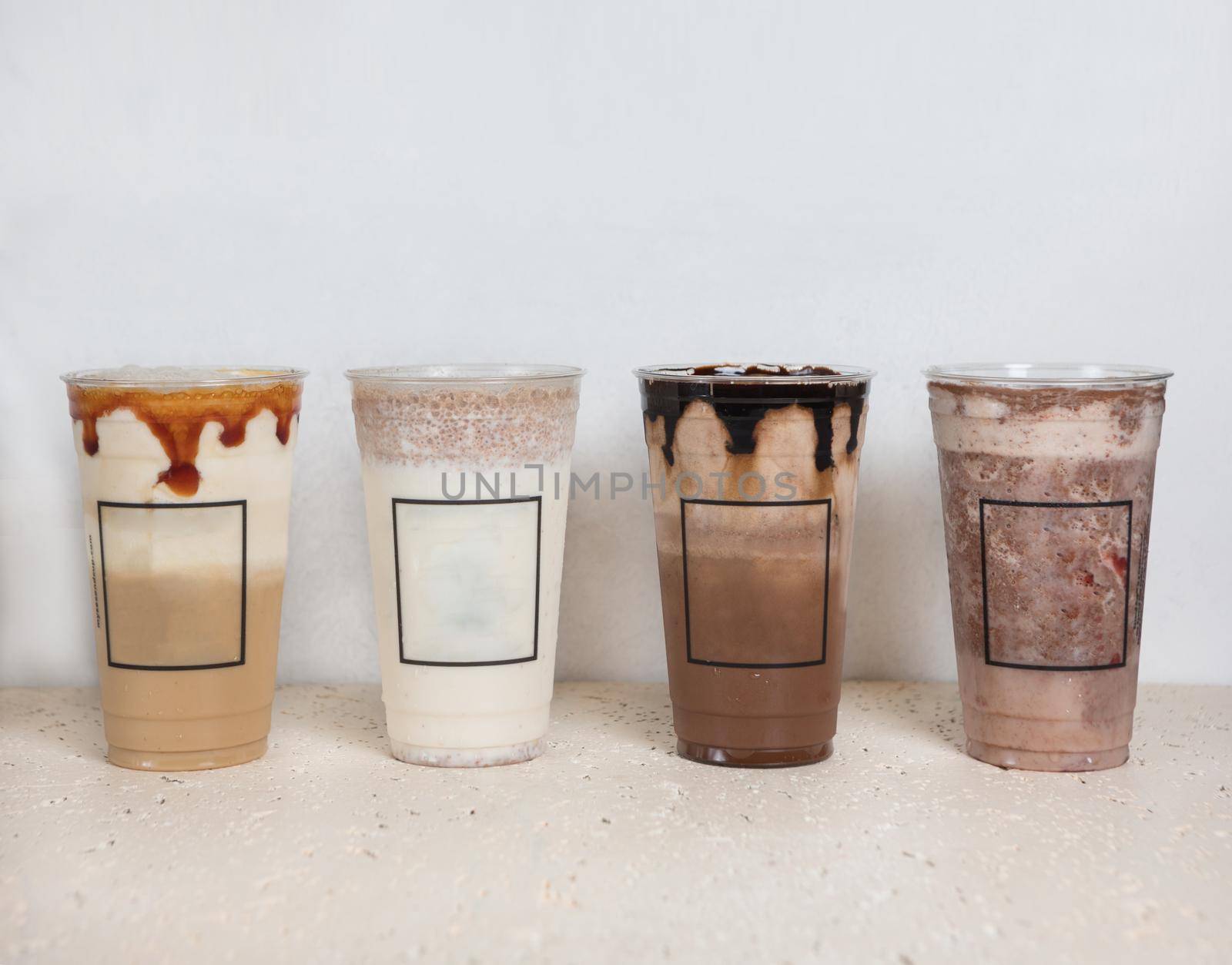 Cold chocolate drinks in plastic cups side by side, white background by ferhad