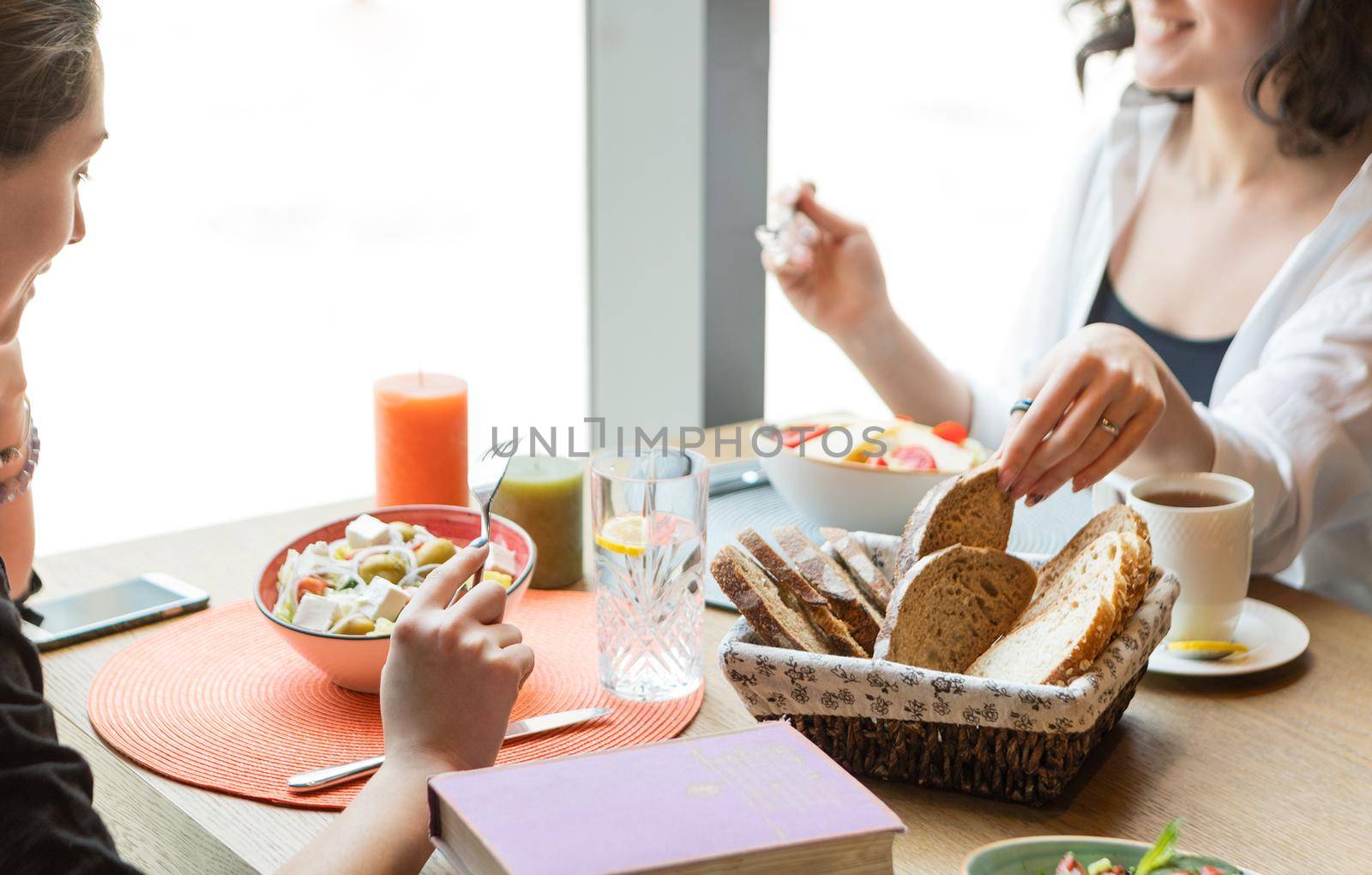 Two woman at dinner, taking bread
