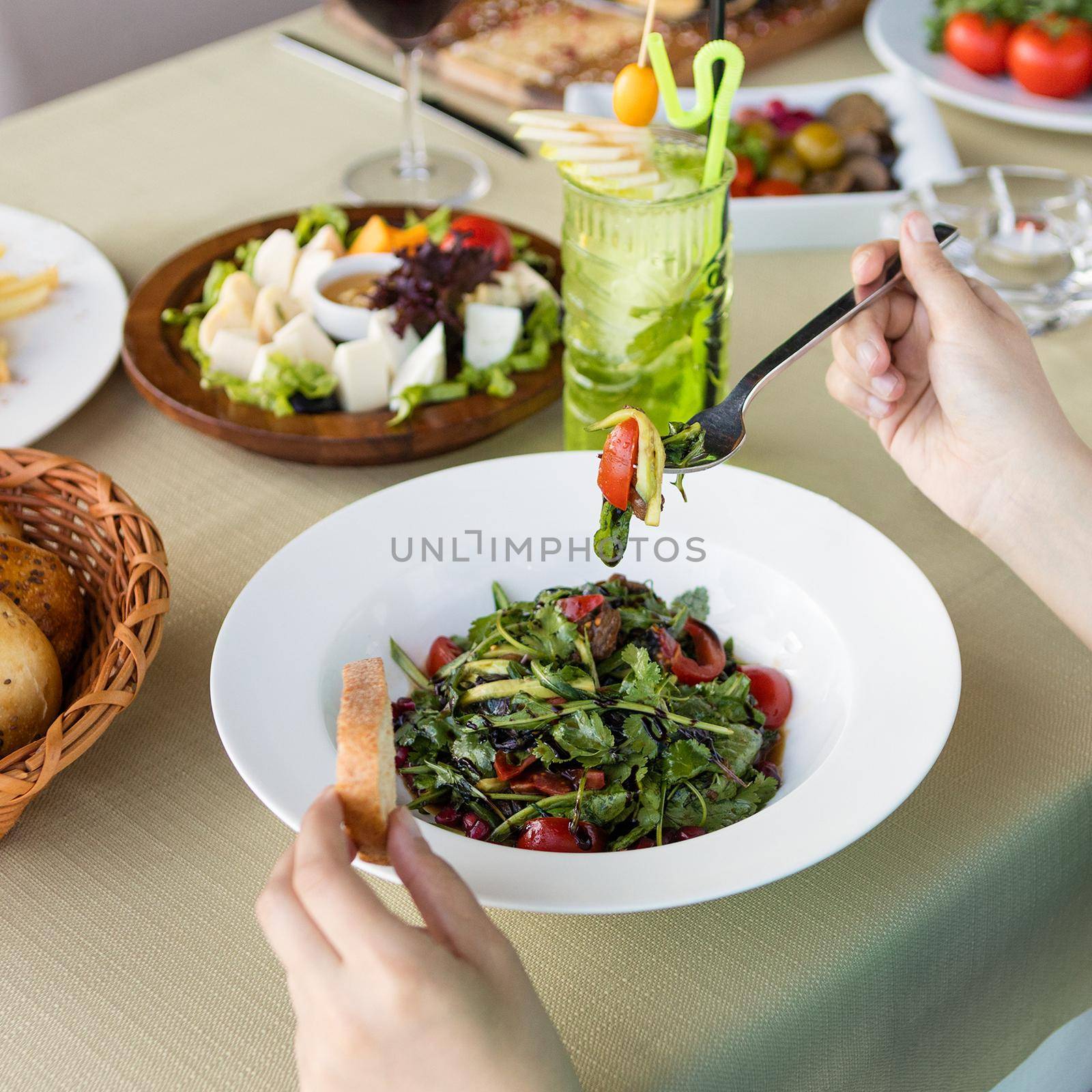 Woman eating vegetarian salad with cheese, cocktail by ferhad