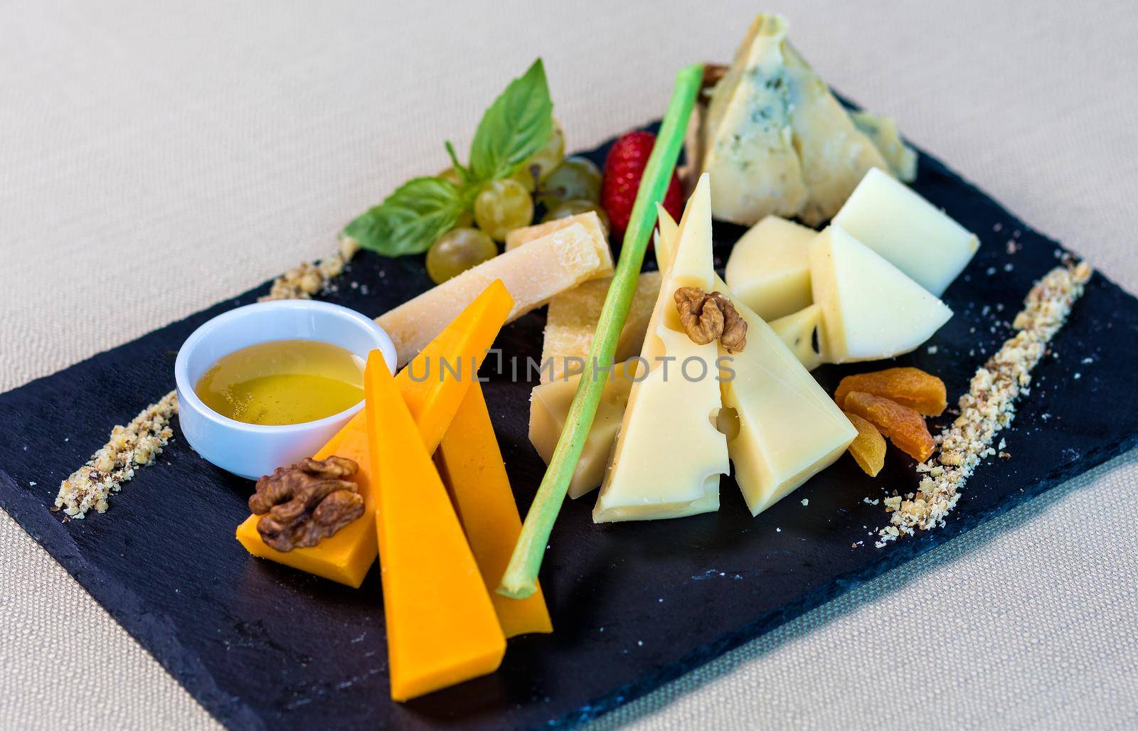 Tasty mixed cheese with sauce on the black plate by ferhad