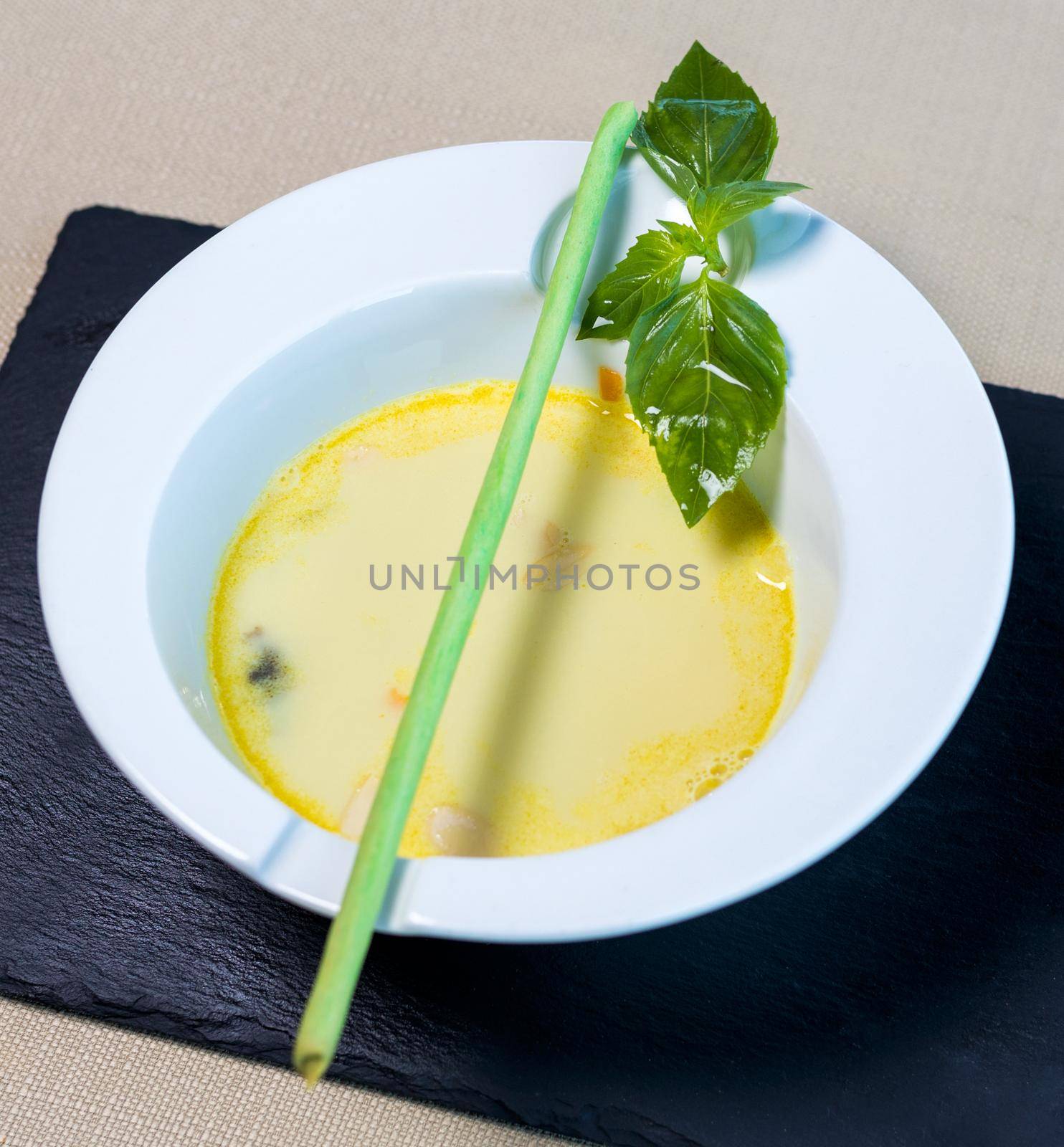 Organic green soup in the white plate close up
