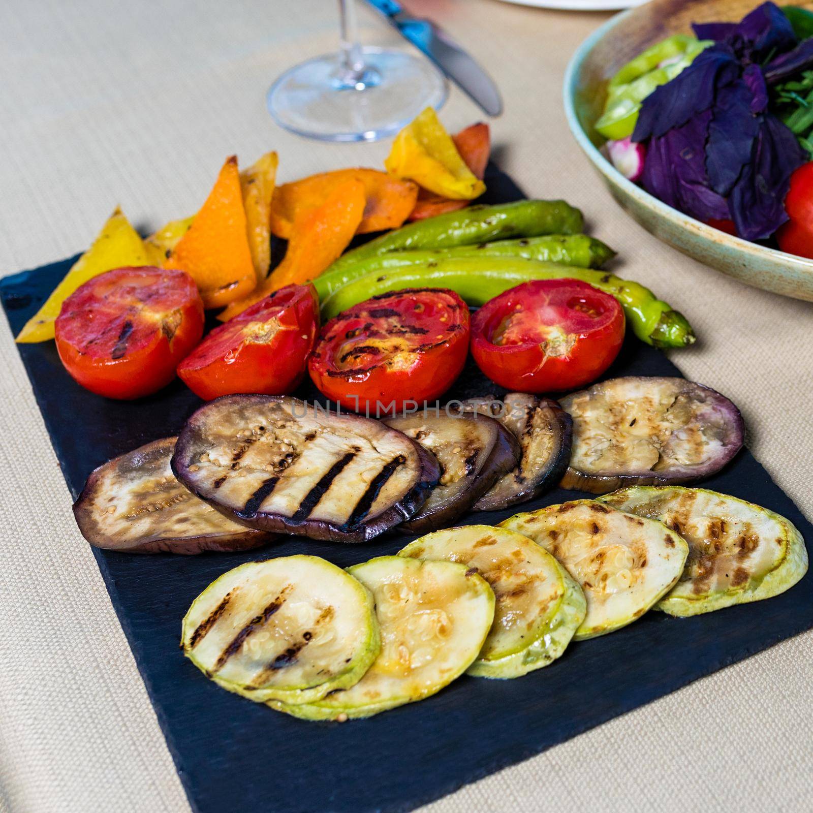 Fried smoked, fruit, vegetable, eggplant, tomato, pepper on a black plate by ferhad