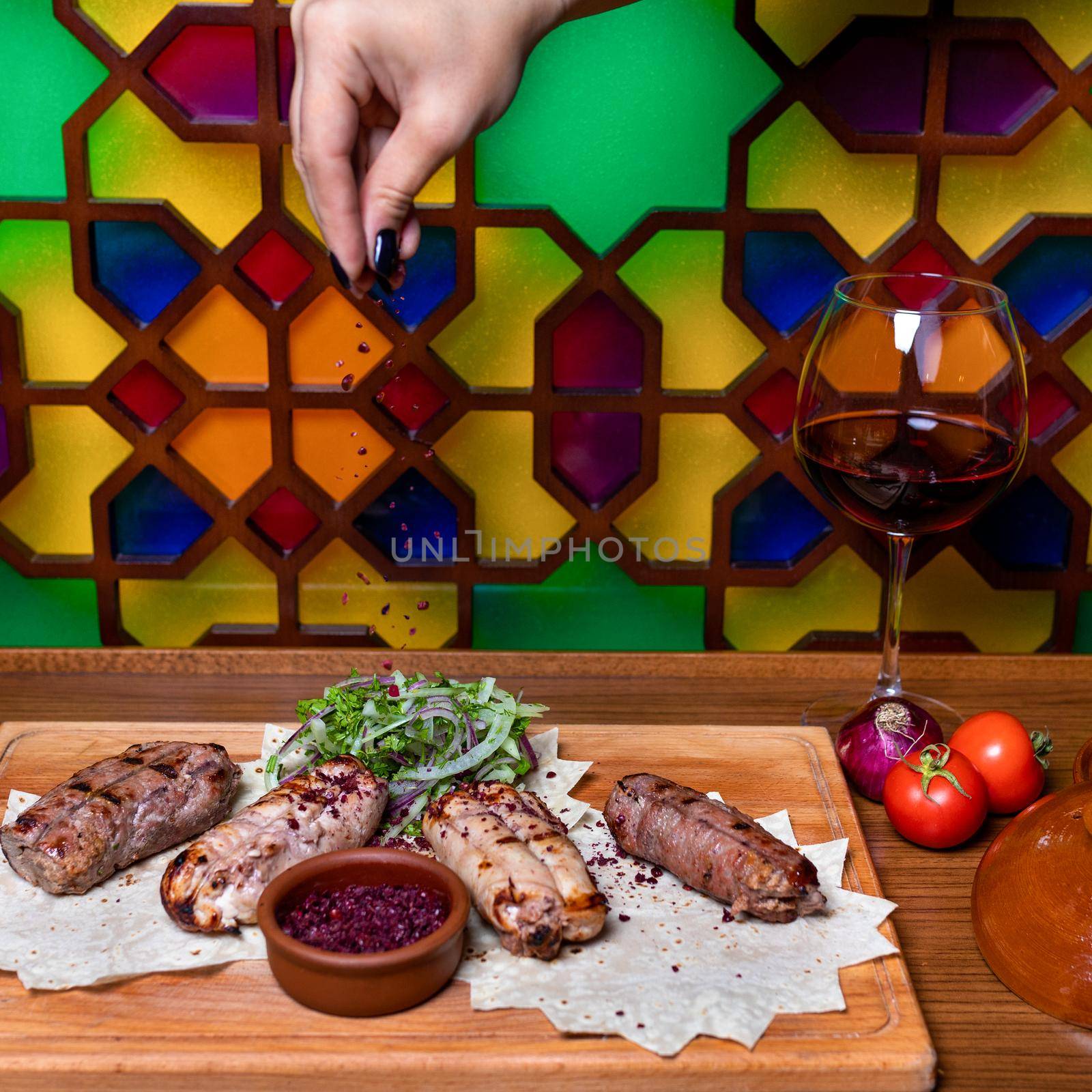 Pouring clove to he Lyulya kebab, sheep meat meal with red wine