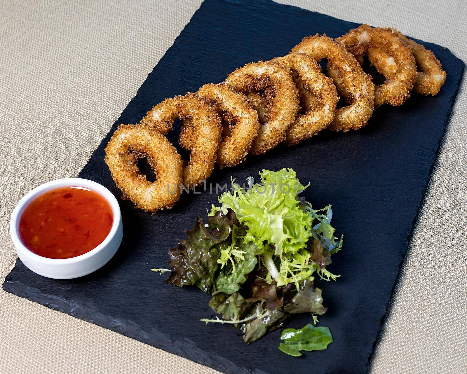 Chicken Ring, nugget, calamari with tomato sauce on the black plate by ferhad