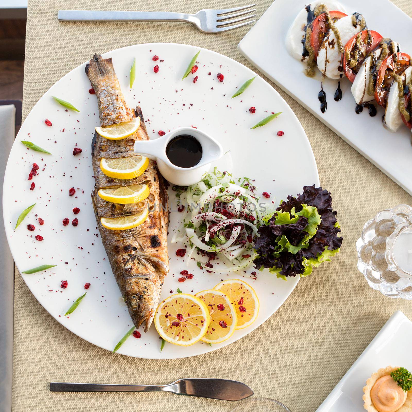 Tasty fish meal with lemon and white wine, top view