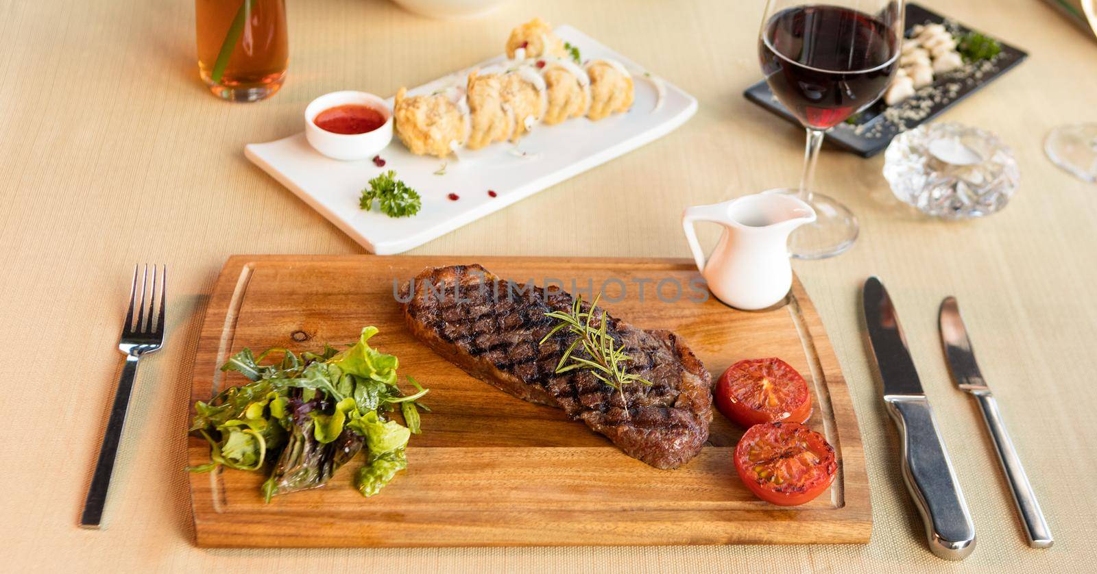 Tasty steak with vegetables on a wooden plate