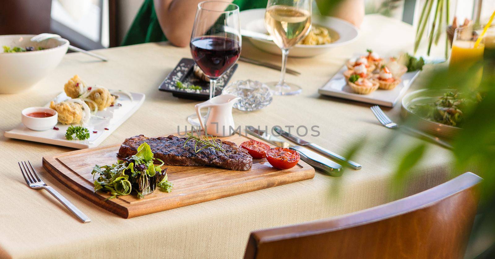 Tasty steak with vegetables on a wooden plate, garnish, red wine by ferhad