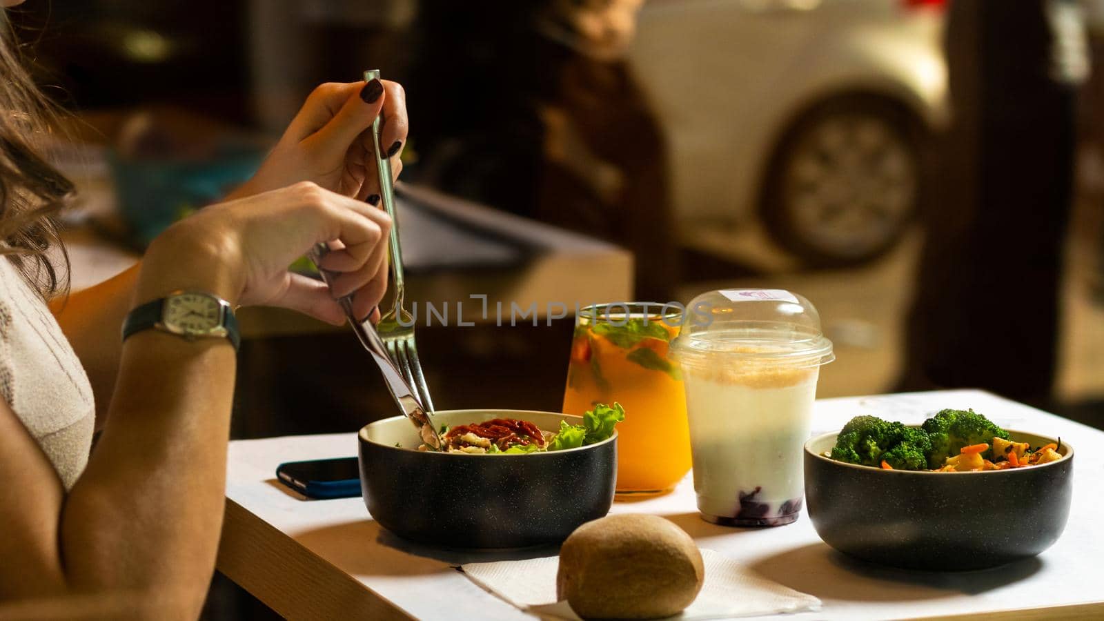 Woman eating tasty chicken salad with dessert